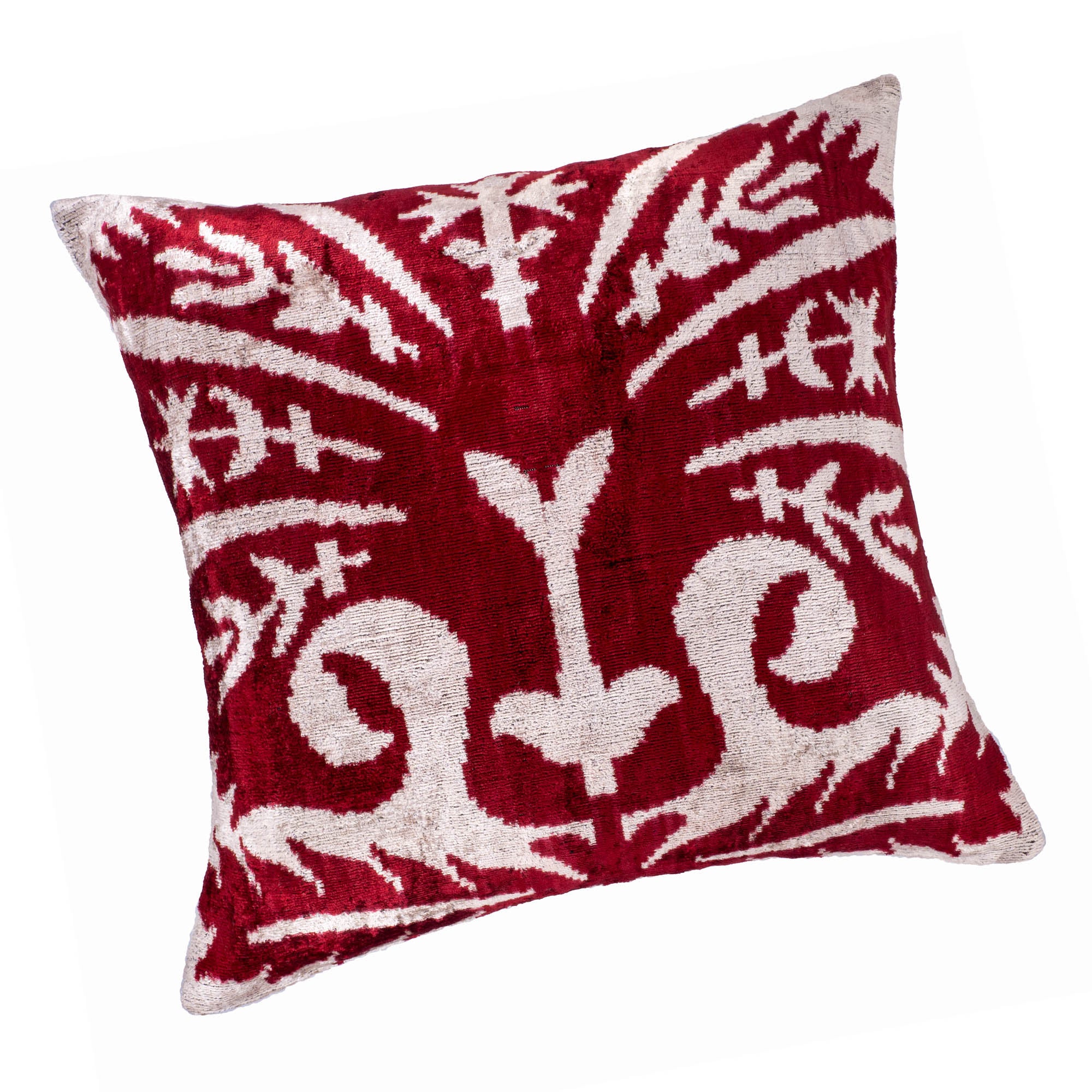 Peacock Ikat pillow with rich red tones and a striking white floral pattern, 20" x 20".