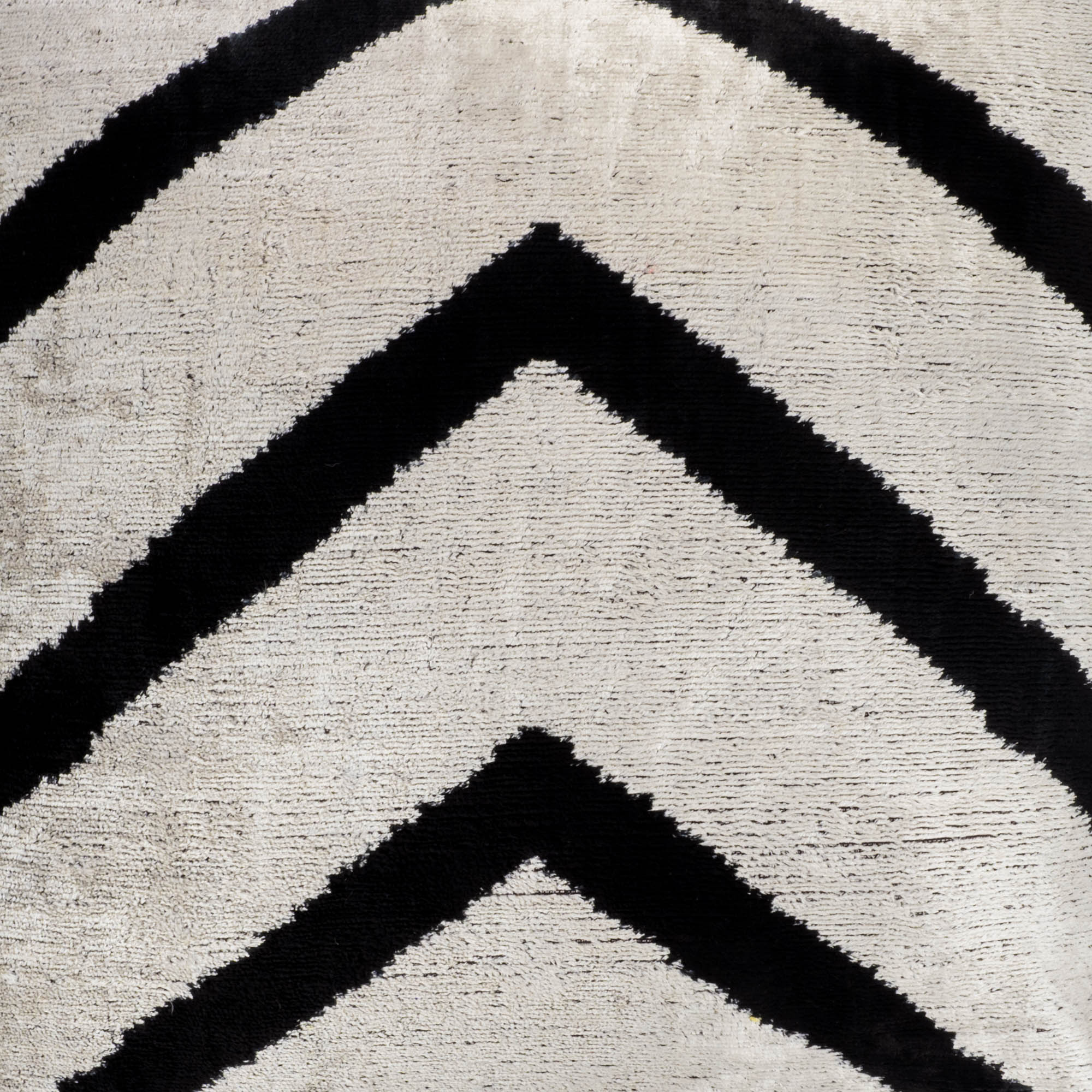 Handcrafted Ikat pillow with bold black zigzag designs on a silver velvet background, 20" x 20".