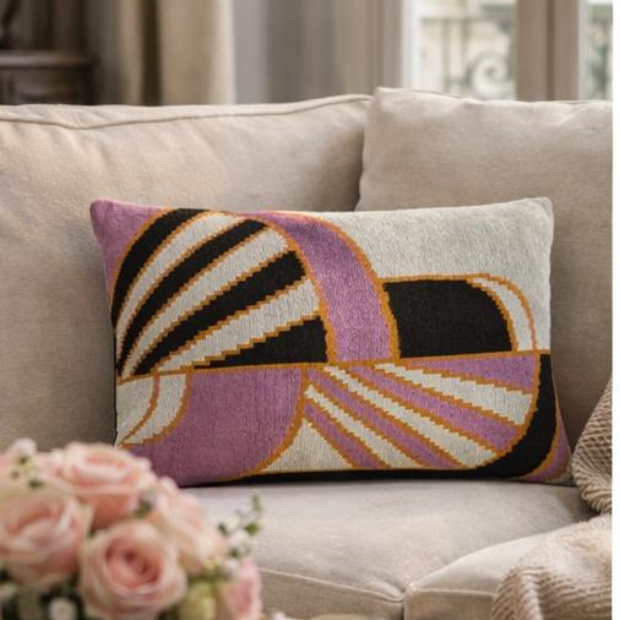geometric embroidered silk velvet throw pillow styled in an elegant living room with marble coffee table and warm lighting