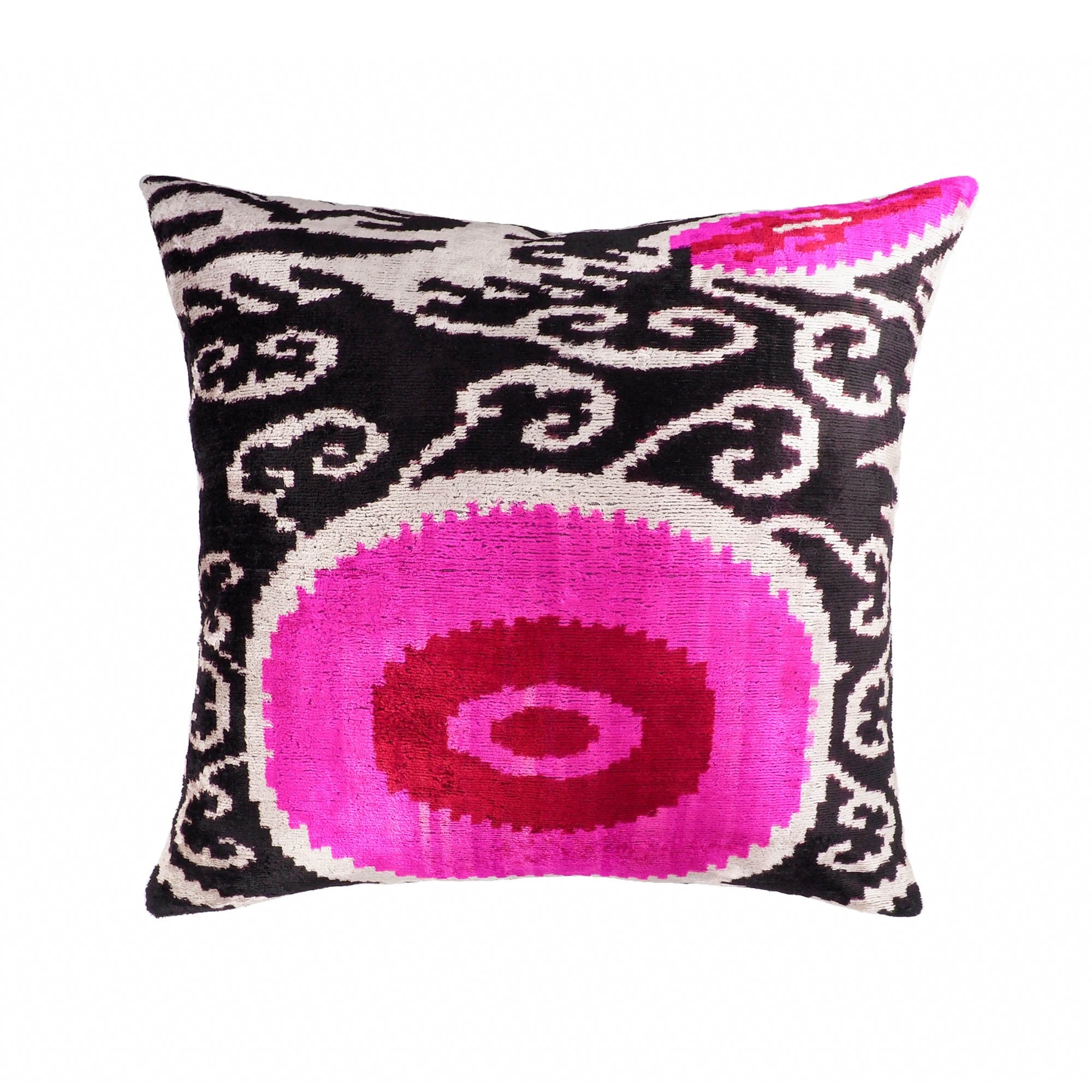 Dogon silk velvet ikat pillow cover with bold magenta and red medallion on black and white scroll background.