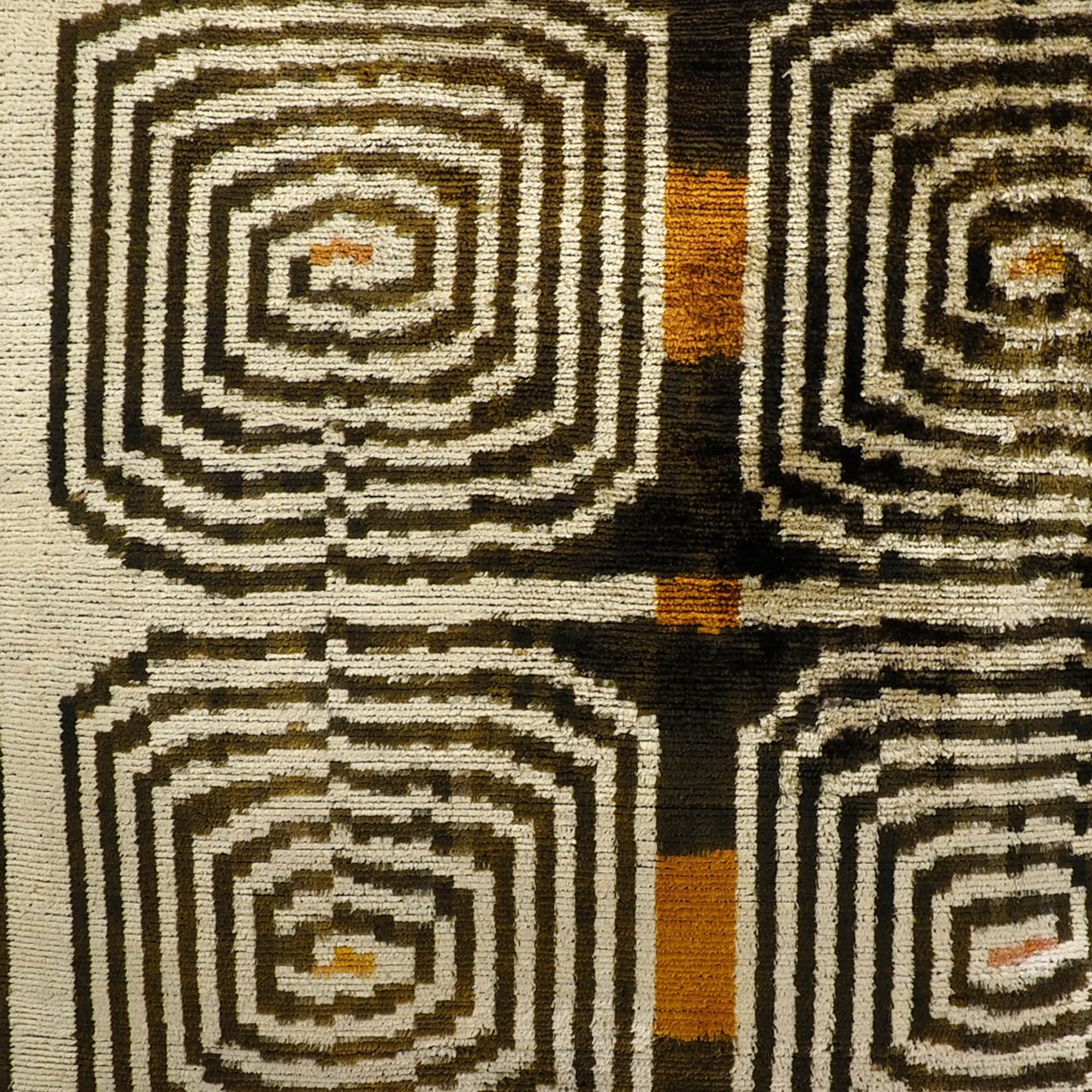 Silk velvet throw pillow with hypnotic labyrinth-inspired ikat motif in warm neutral palette.