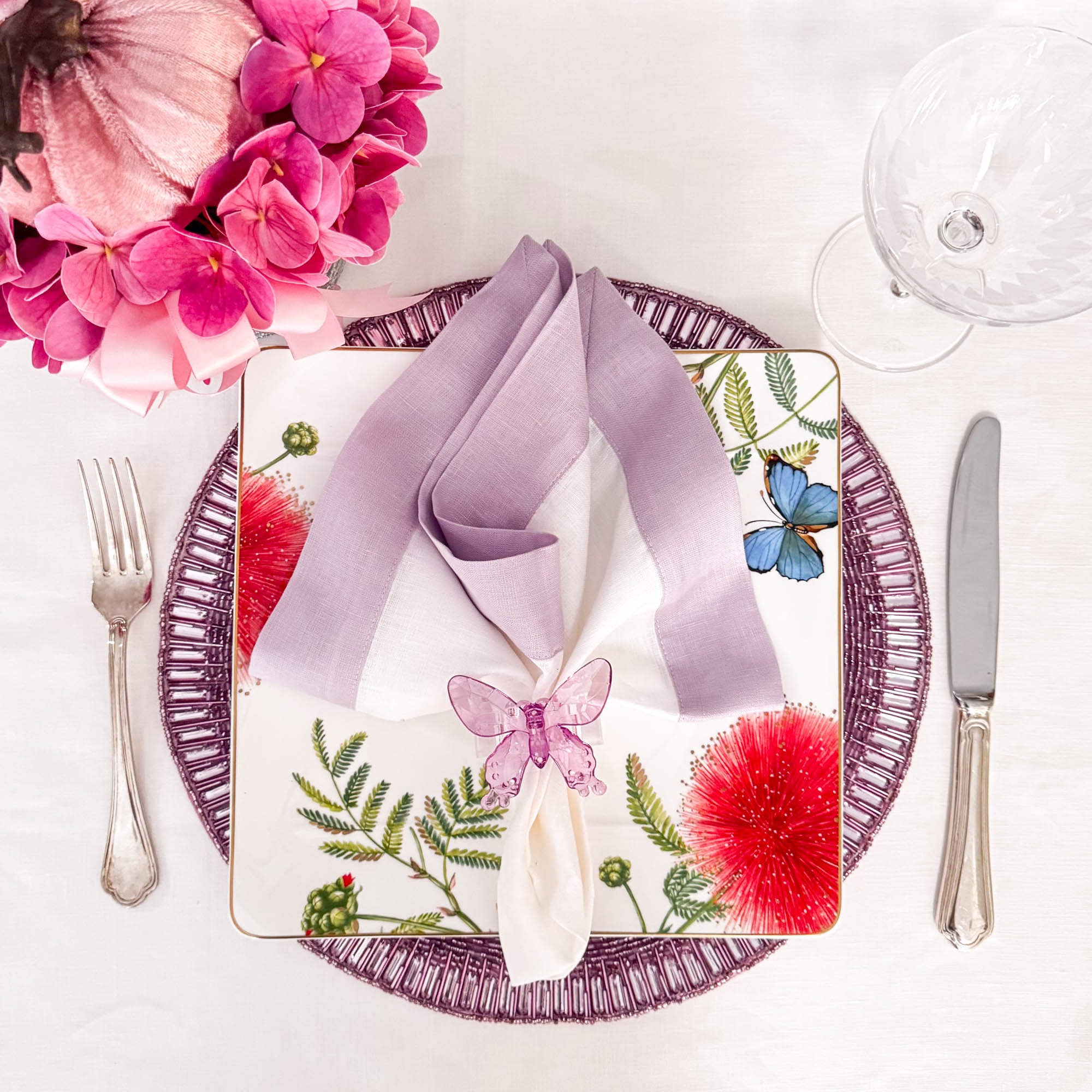 Handmade lavender glass beaded placemat styled with botanical floral plate, lavender bordered linen napkin, and butterfly ring by ChouChou Touch