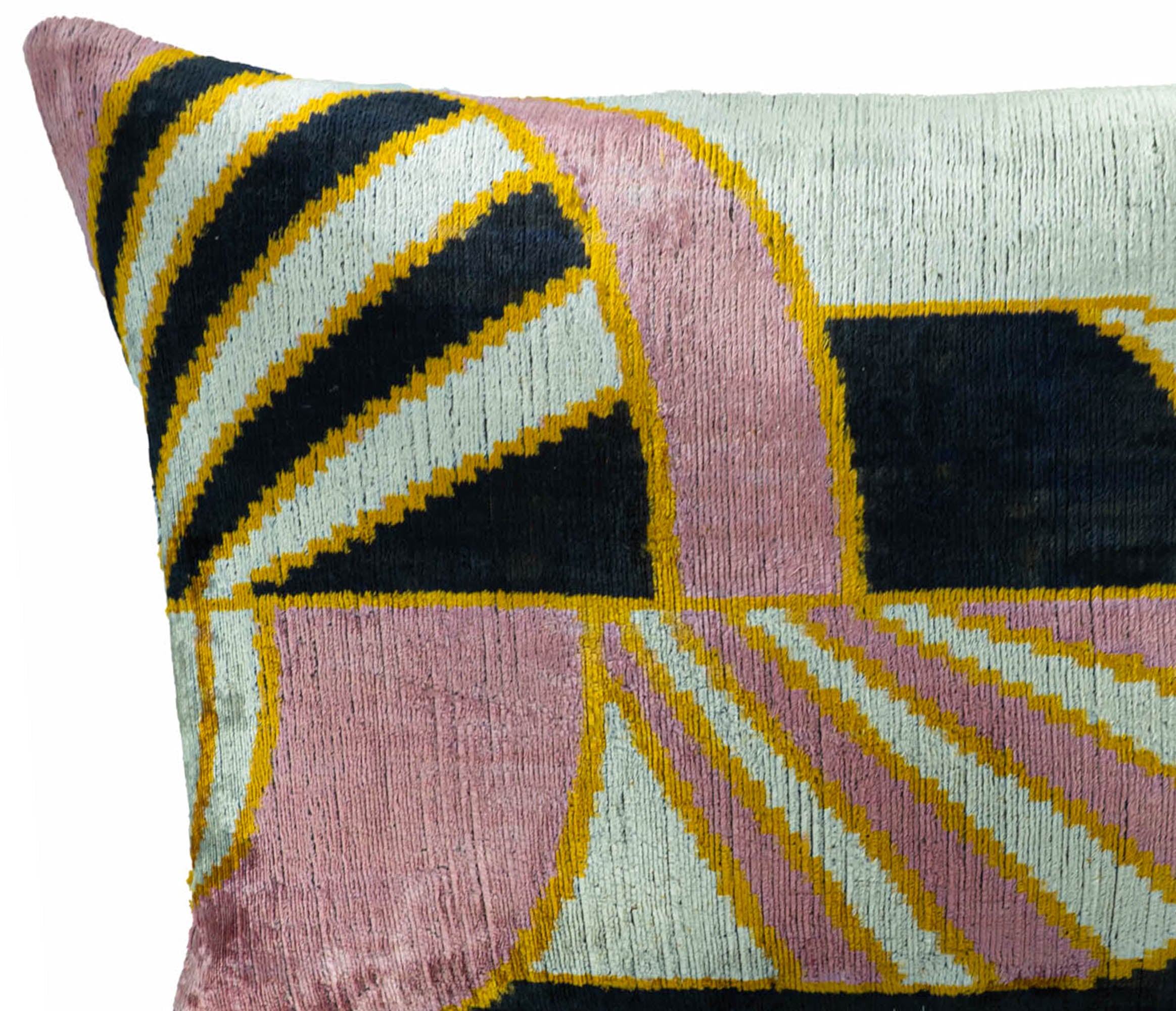 Close-up of a ChouChou Touch handmade silk velvet ikat lumbar pillow featuring blush pink, ivory, black and golden geometric patterns with a luxurious woven texture.