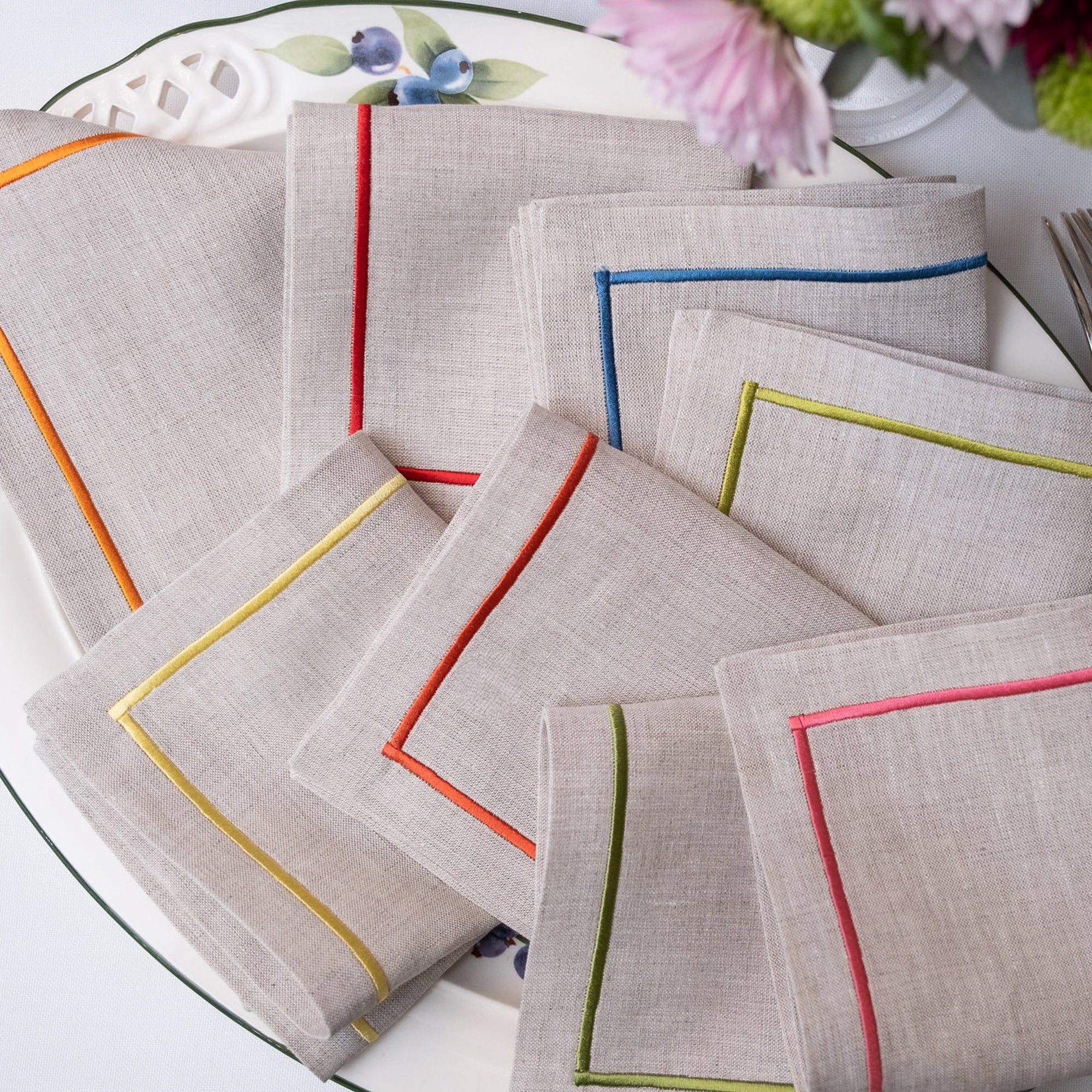 Elegant linen cocktail napkins with colorful embroidered borders for entertaining and table settings