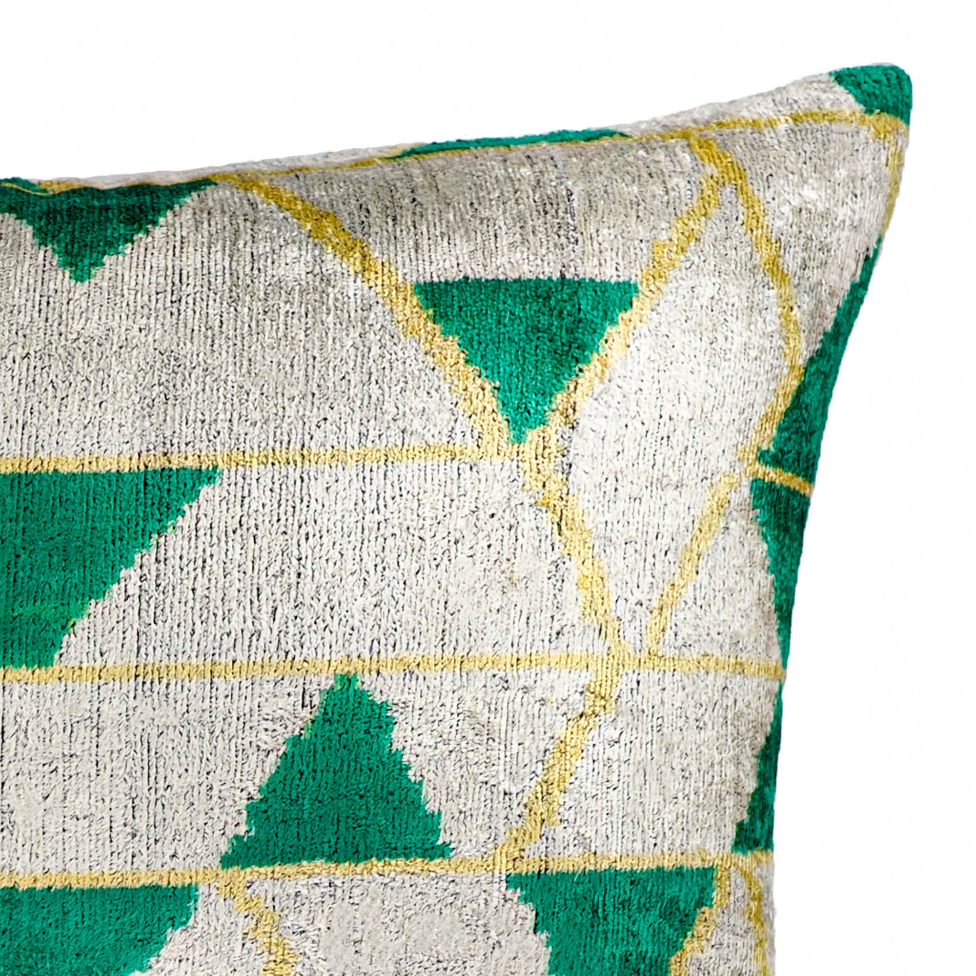 Modern tribal-style silk velvet pillow with green geometric pattern on white base.
