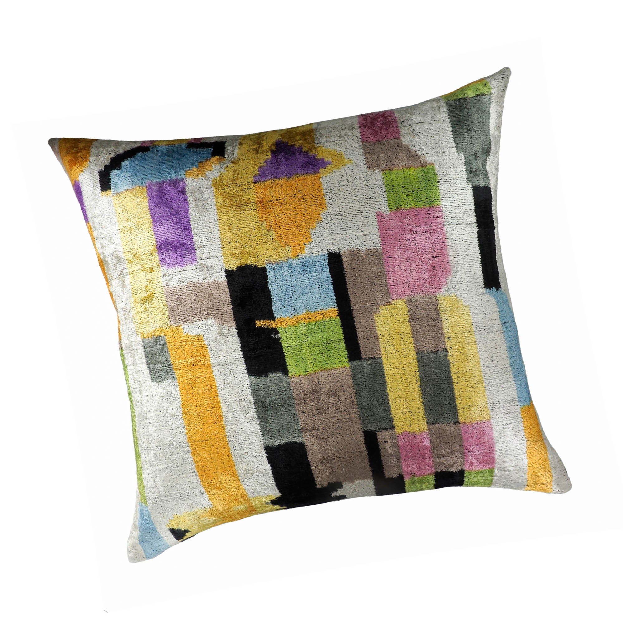 Chouchou Touch Marco pillow featuring bold ikat blocks in vibrant jewel tones on a soft silver background.