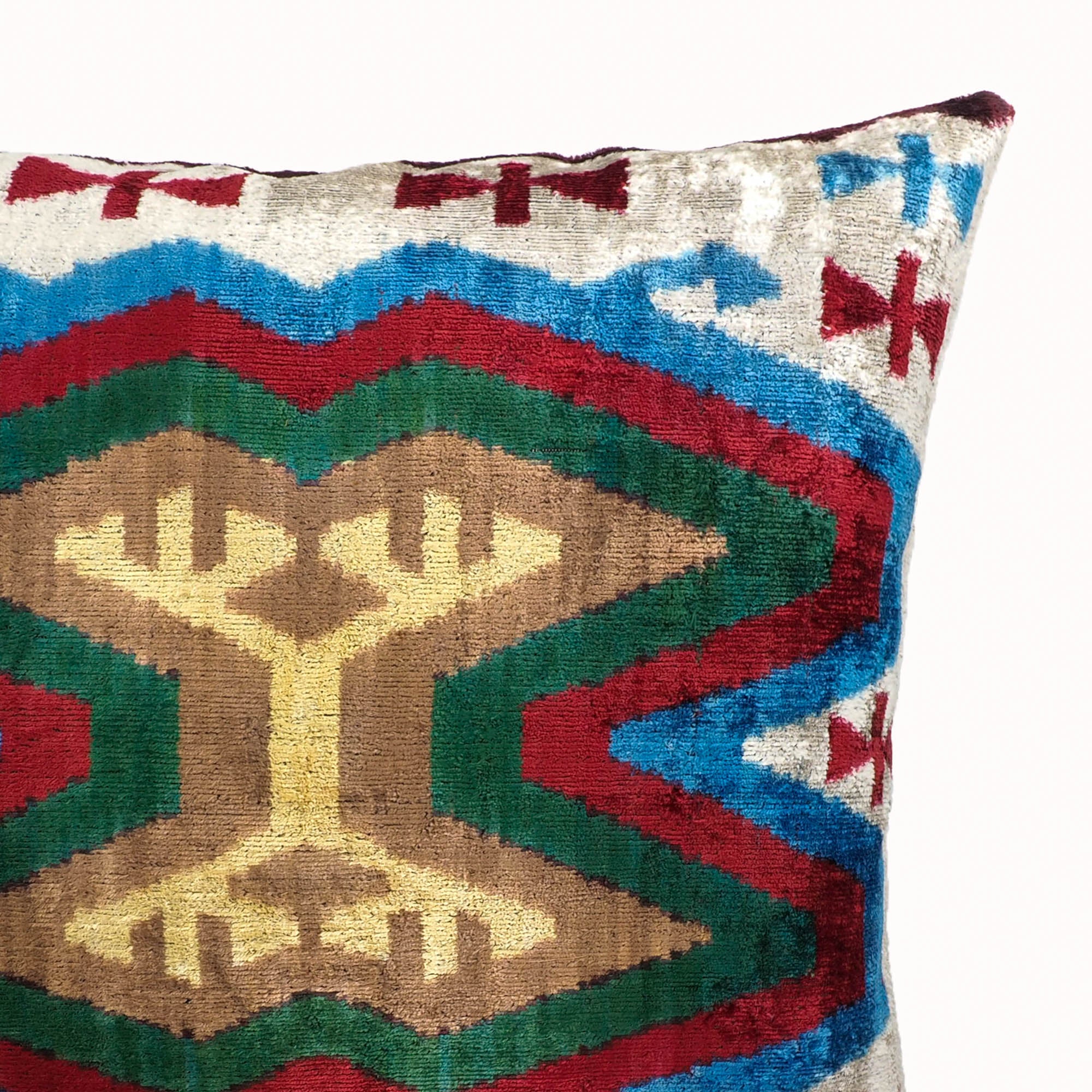 Bohemian square pillow with vibrant velvet texture and ethnic pattern in earth and jewel tones.