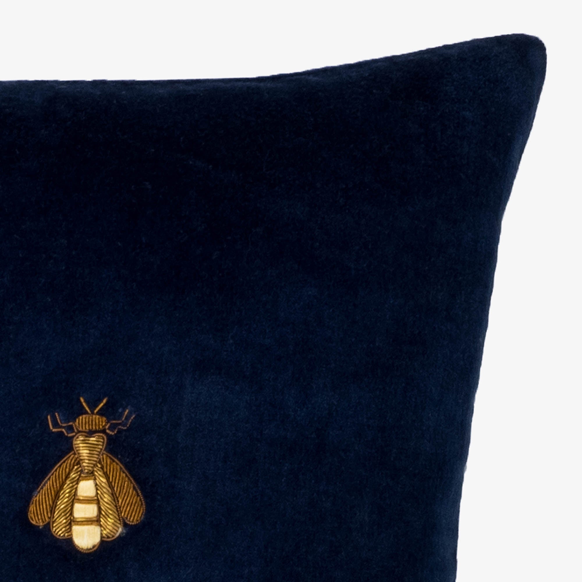 close up of gold embroidered bee detail on navy blue silk velvet pillow cover, showcasing rich texture and fine craftsmanship