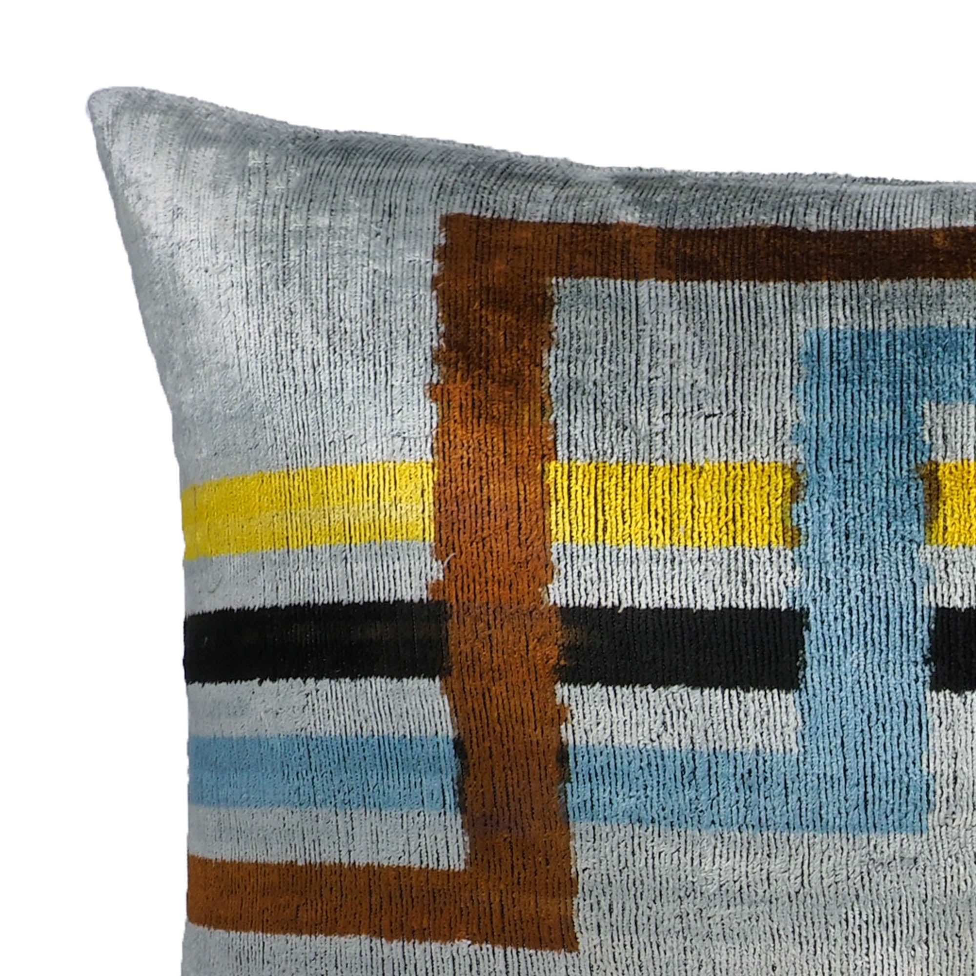 Modern silk ikat cushion in grey with overlapping rectangles in bronze, yellow, black, and sky blue.