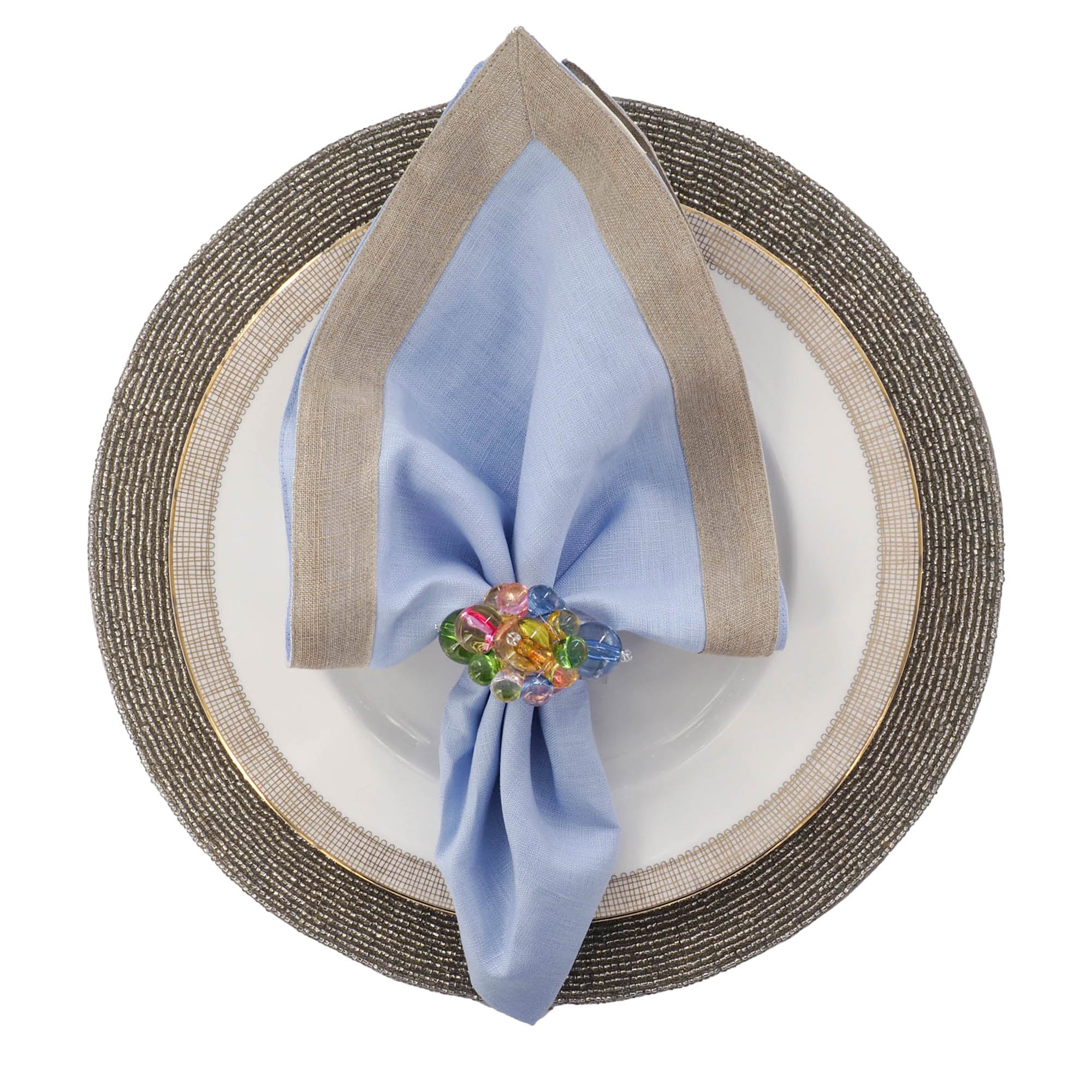 Elegant tropical table setup with handmade glass beaded placemat in palm leaf pattern, accented with gold tones and blue linen napkin by ChouChou Touch