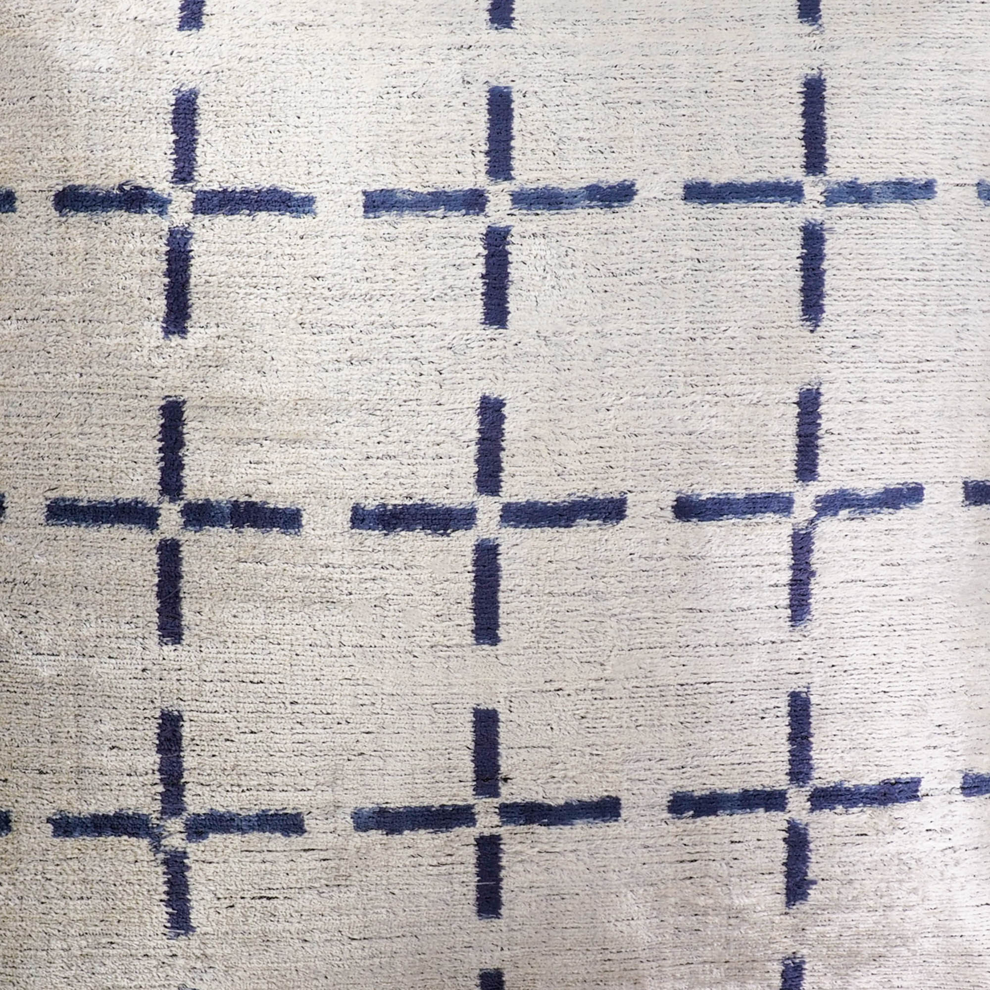 Contemporary ikat pillow with navy blue intersecting lines on shimmering silk velvet.