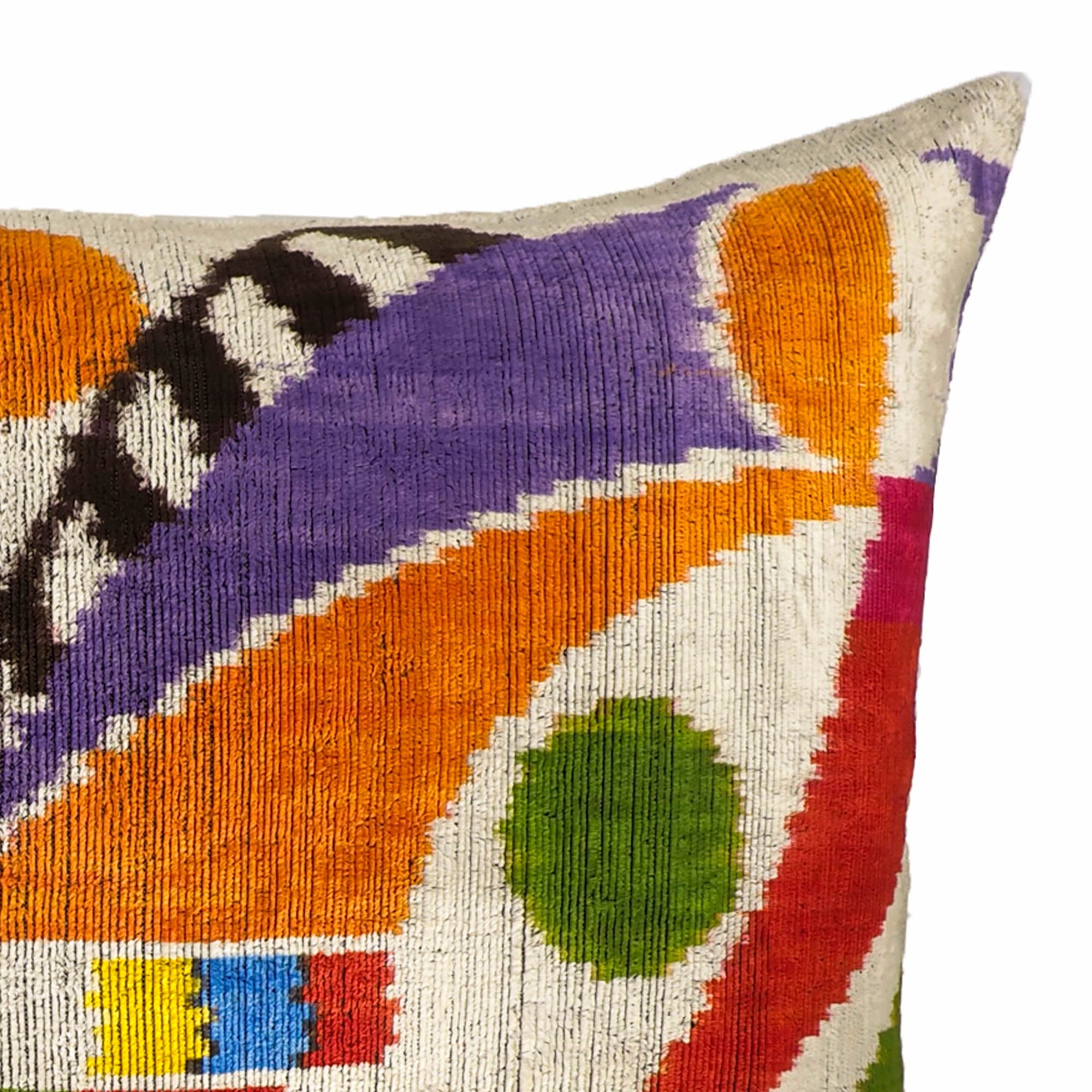 Art-inspired ikat pillow with concentric circles and curved motifs in multicolor palette.