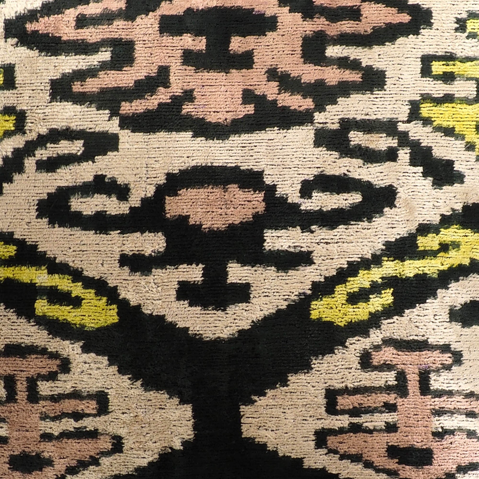 Boho-style silk velvet pillow cover with symmetrical ikat design in soft and rich shades.