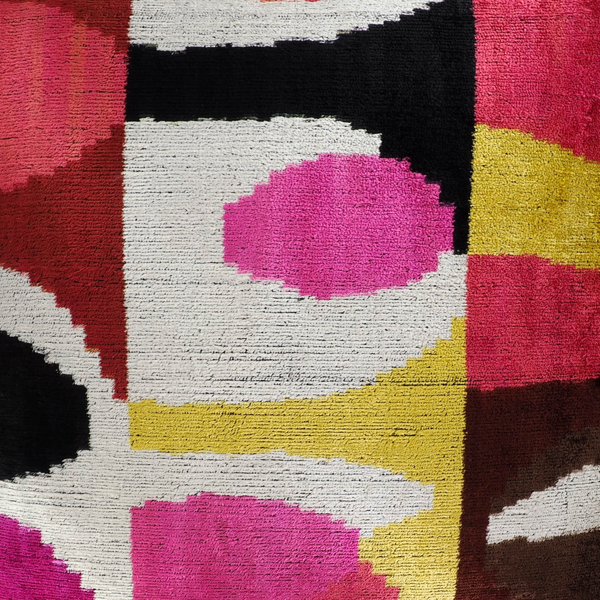 Artistic throw pillow in rich jewel tones featuring abstract ikat design on silk velvet.