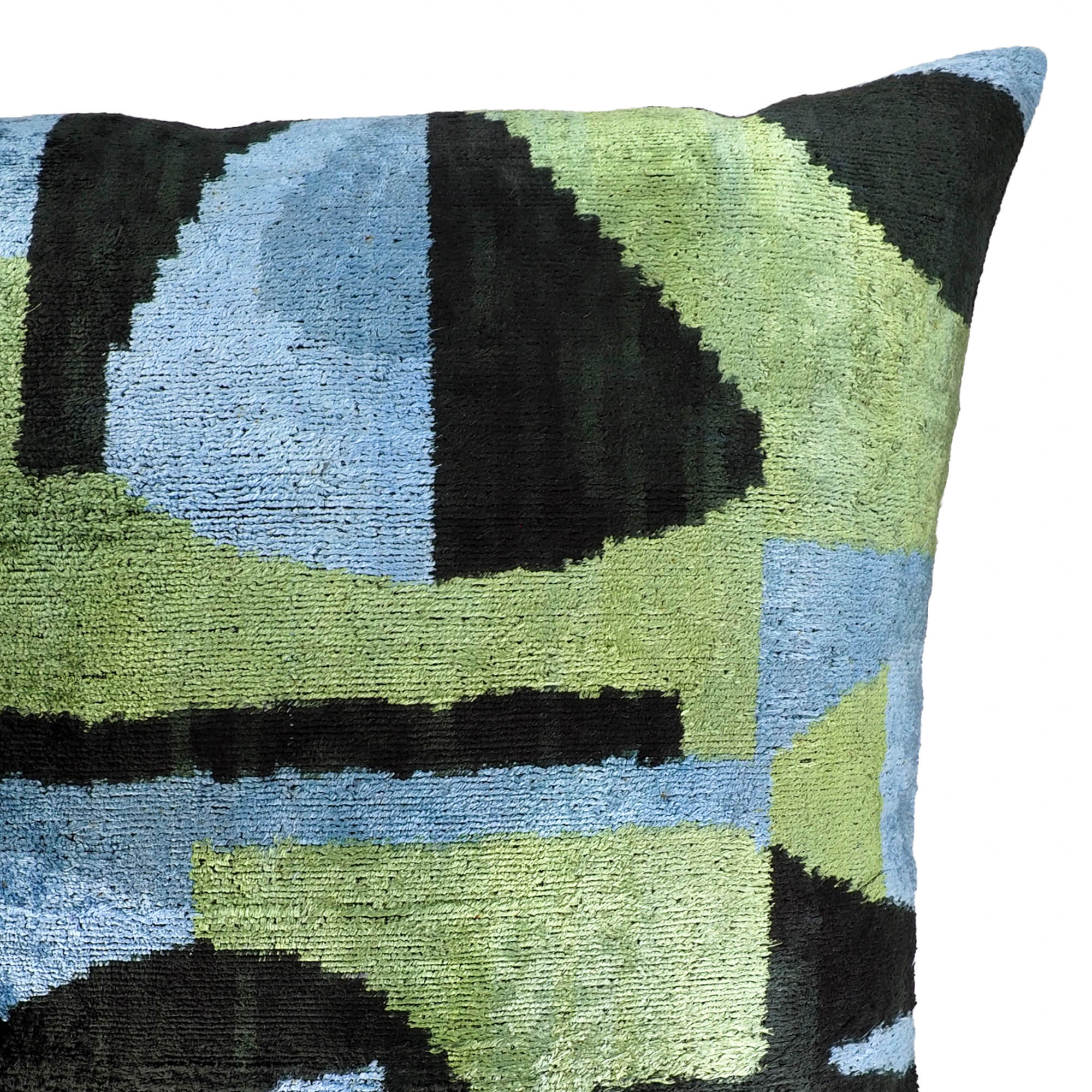 Contemporary ikat pillow with curved geometric shapes in forest green, sky blue, and deep black.