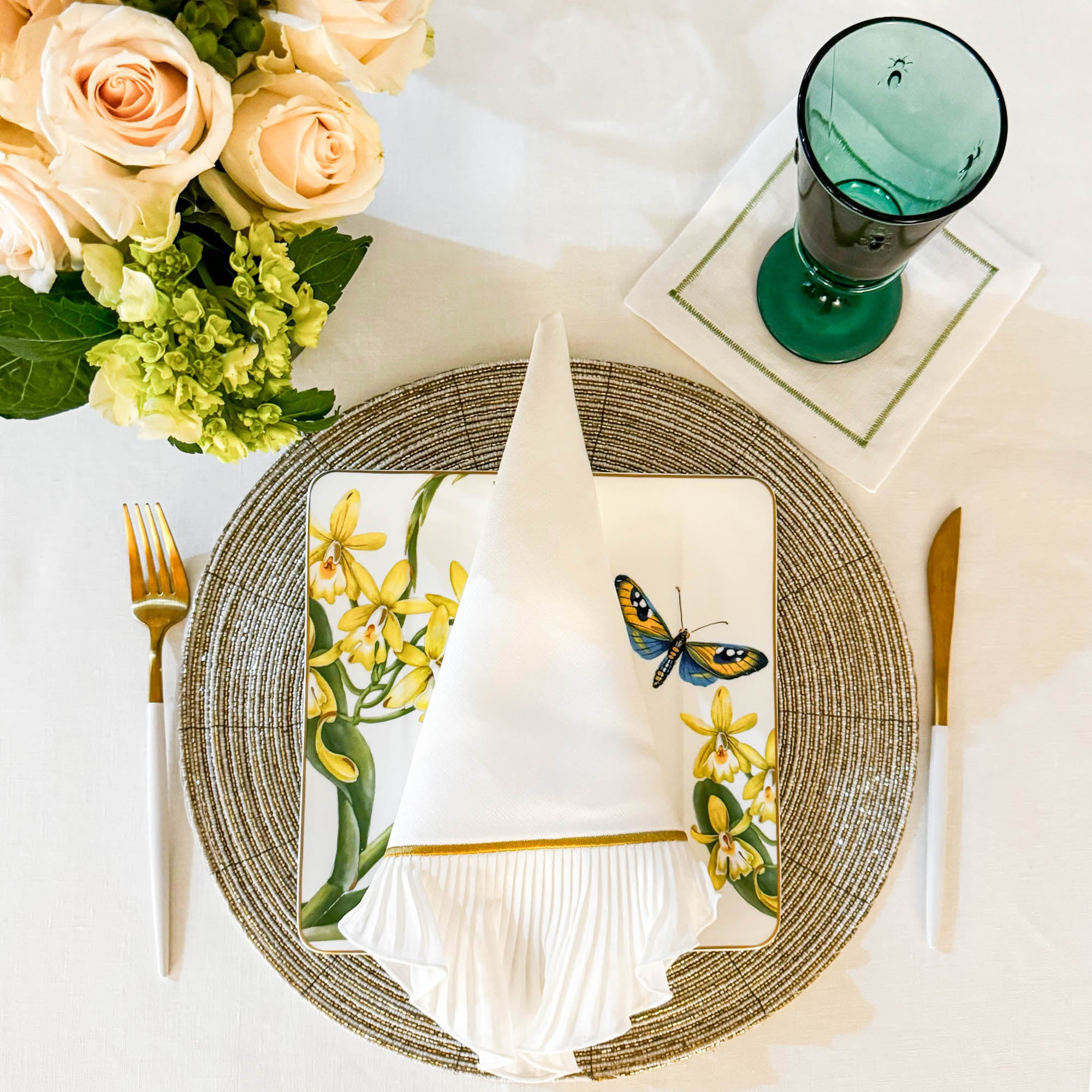 Elegant table setting featuring handmade gold and ivory glass beaded placemat with white linen napkin and gold cutlery by ChouChou Touch