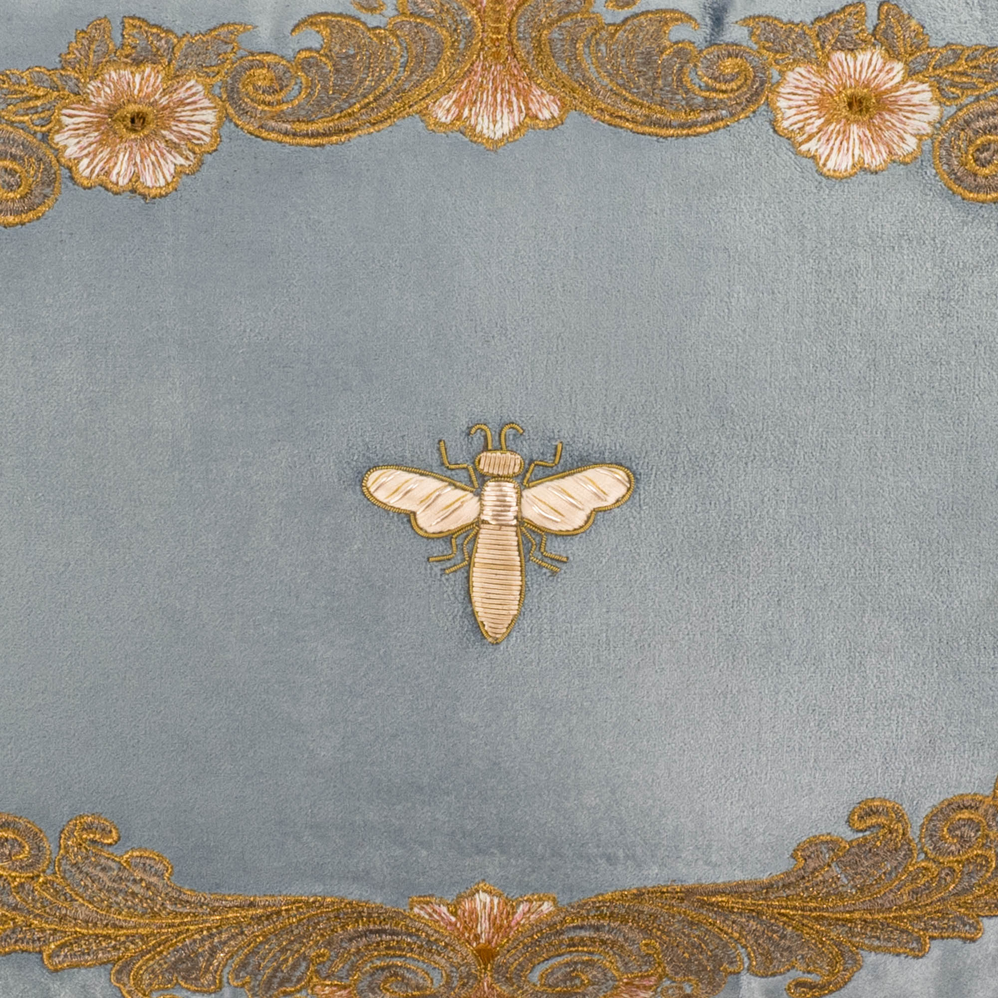 Close-up of Venice Blue pillow cover with detailed golden embroidery and central bee motif