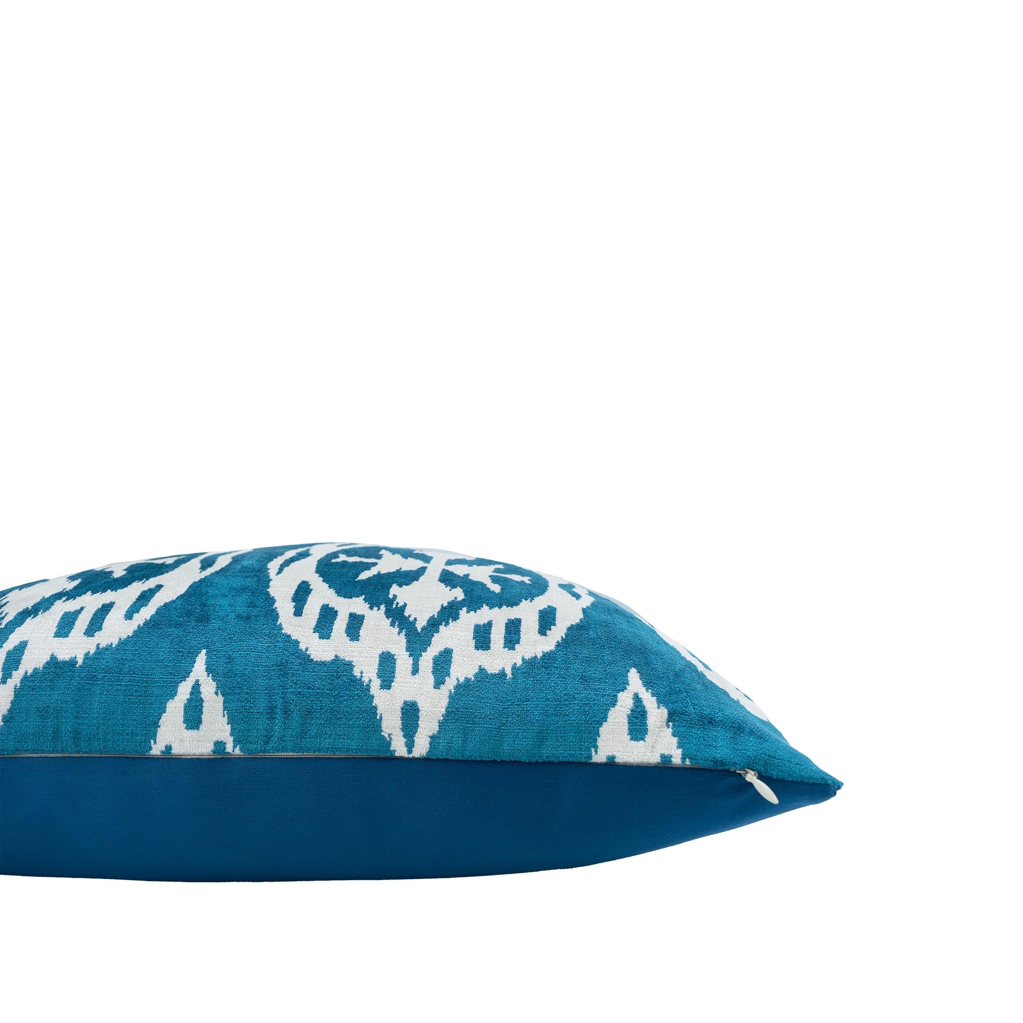 Handwoven silk velvet ikat pillow featuring a bold symmetrical medallion design in rich blue and crisp white.