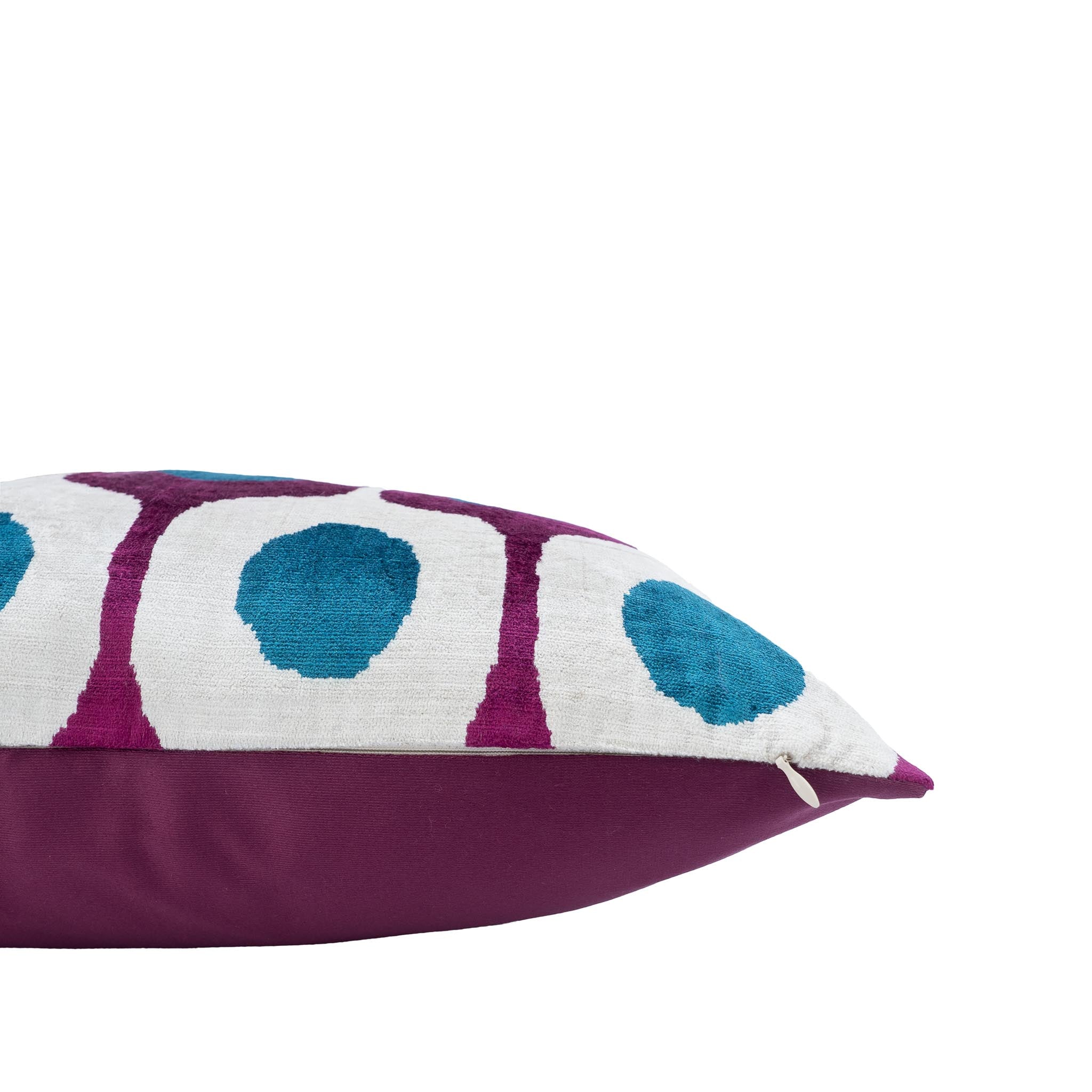 Handwoven silk velvet ikat pillow featuring bold geometric circles in vibrant magenta and blue hues.