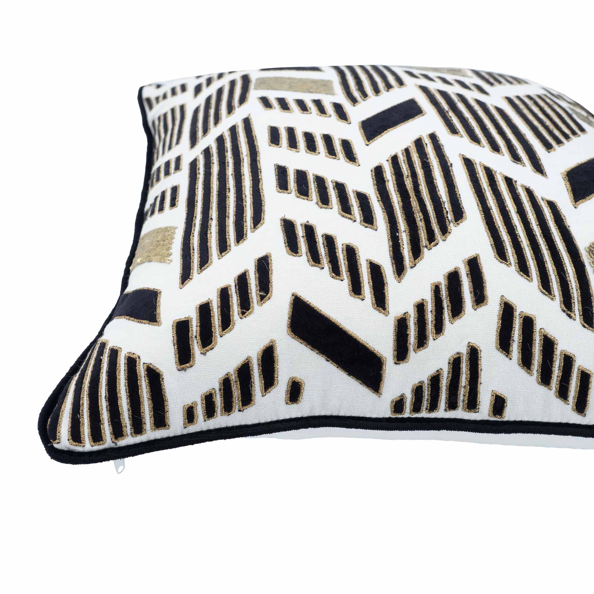 Inca-inspired gold embroidered pillow with black velvet trim on white background.