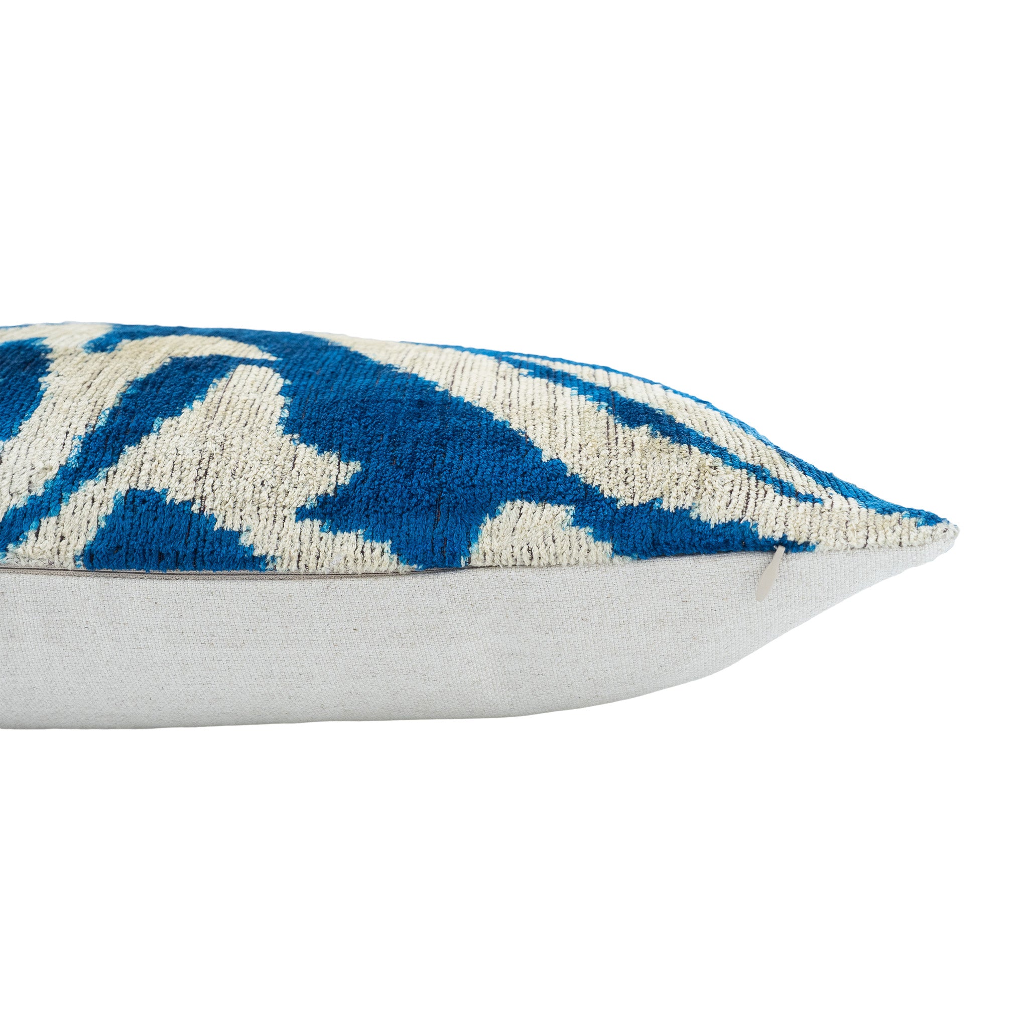 Chouchou Touch silk velvet ikat pillow featuring white botanical pattern on rich blue.