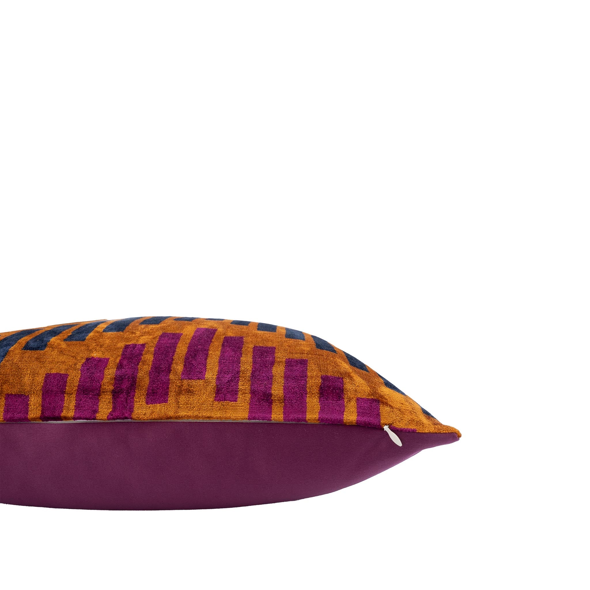 Stylish silk velvet pillow with a sophisticated geometric ikat motif in warm gold, deep blue, and magenta hues.