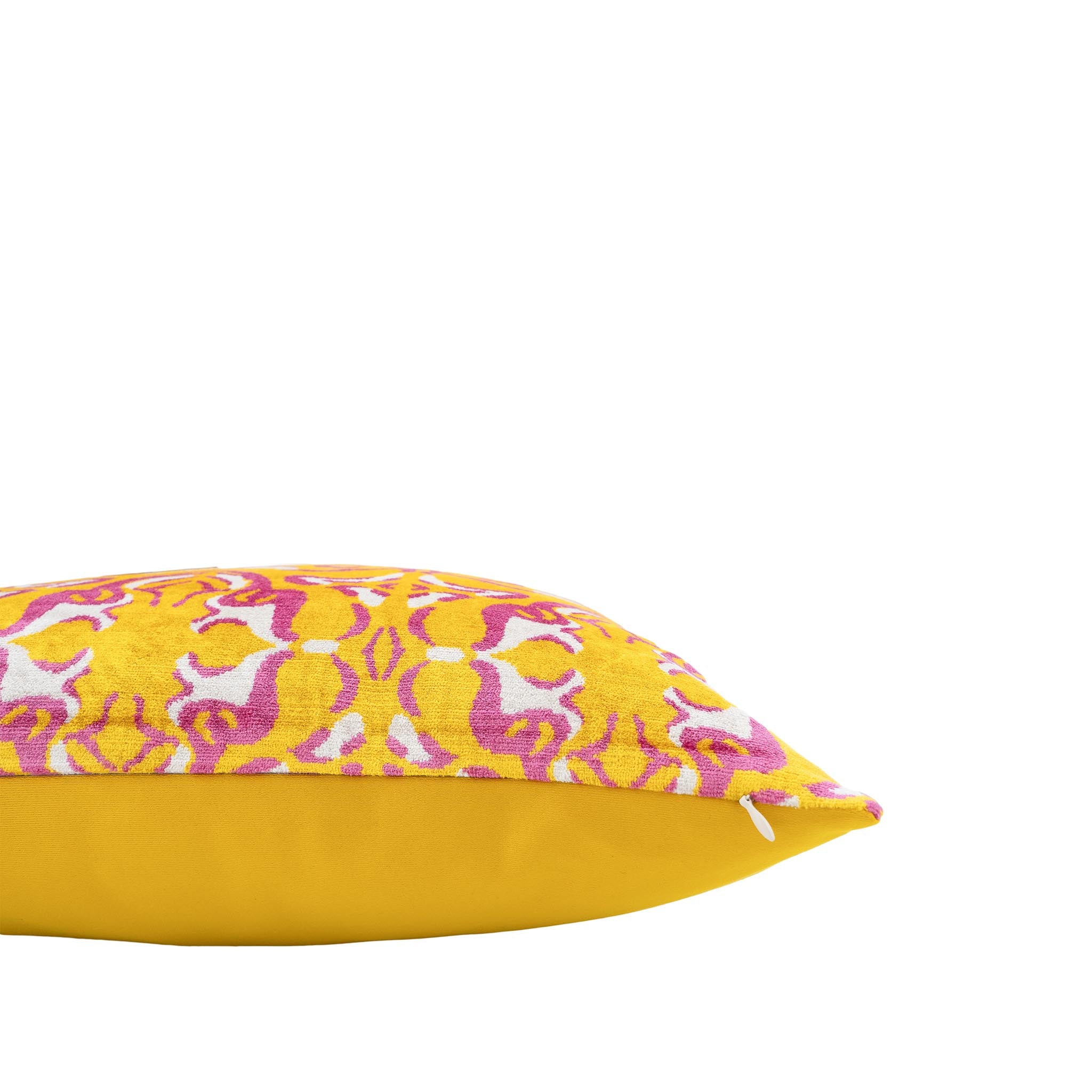 Kaleidoscope-inspired decorative pillow with intricate pink and white accents on a yellow background.