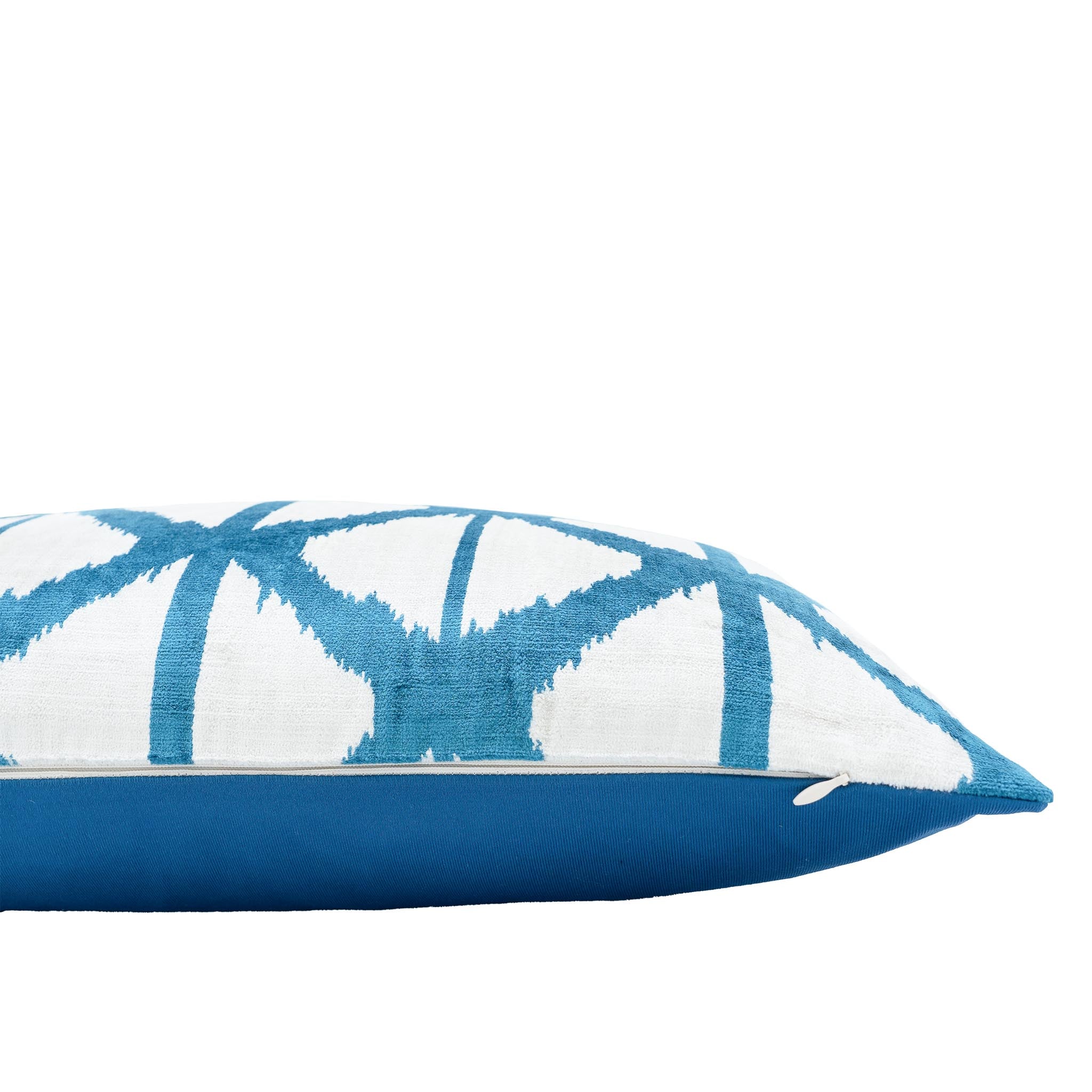 Handmade silk velvet ikat cushion in turquoise and white with intersecting arcs.