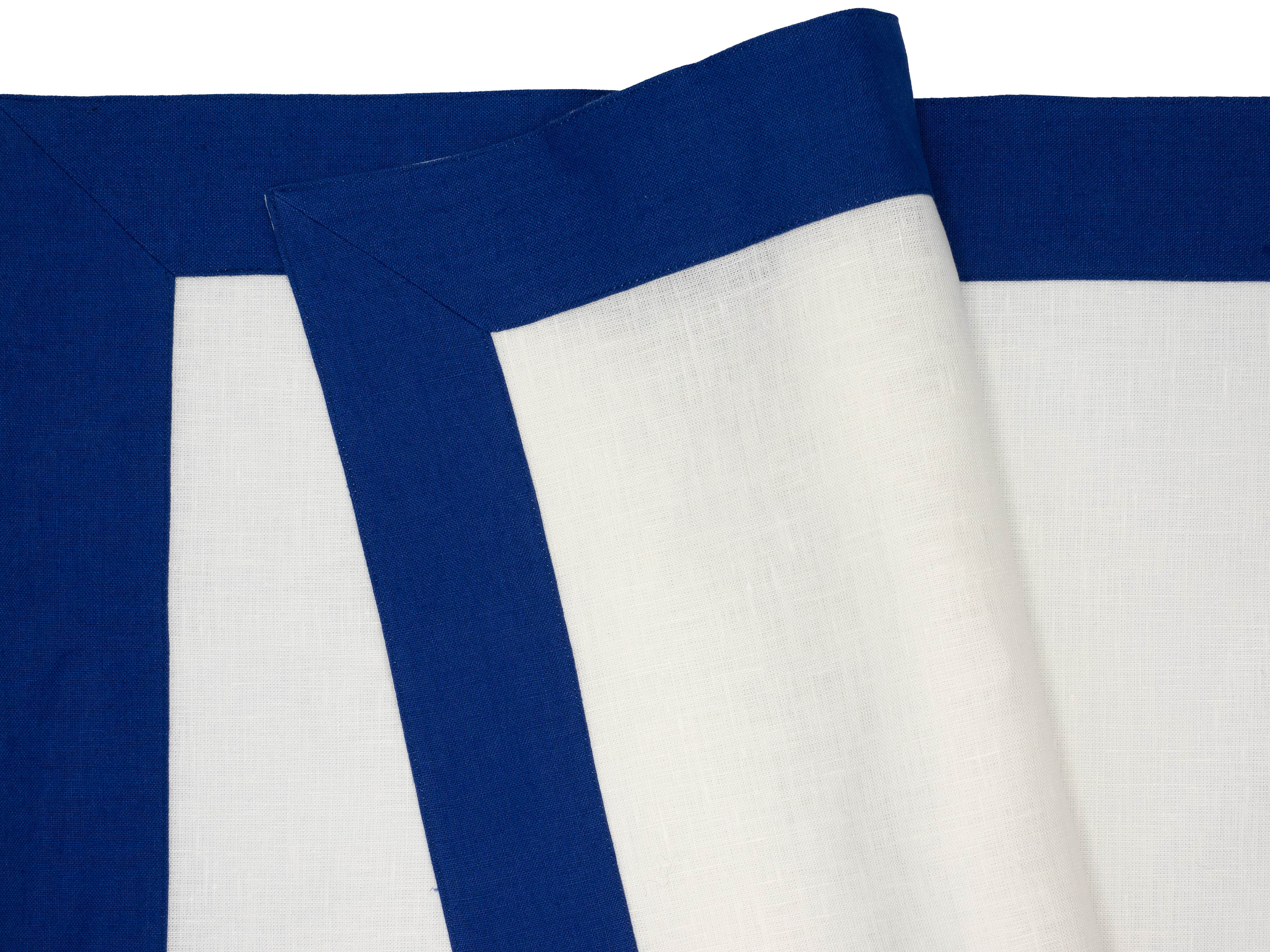 Elegant linen placemats with navy borders, meticulously crafted by skilled artisans for long-lasting use and beauty.