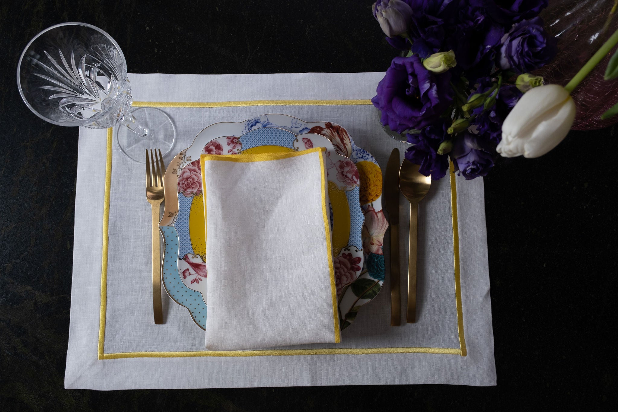 Set of 4 white linen placemats with yellow borders, blending practicality and style in every piece.