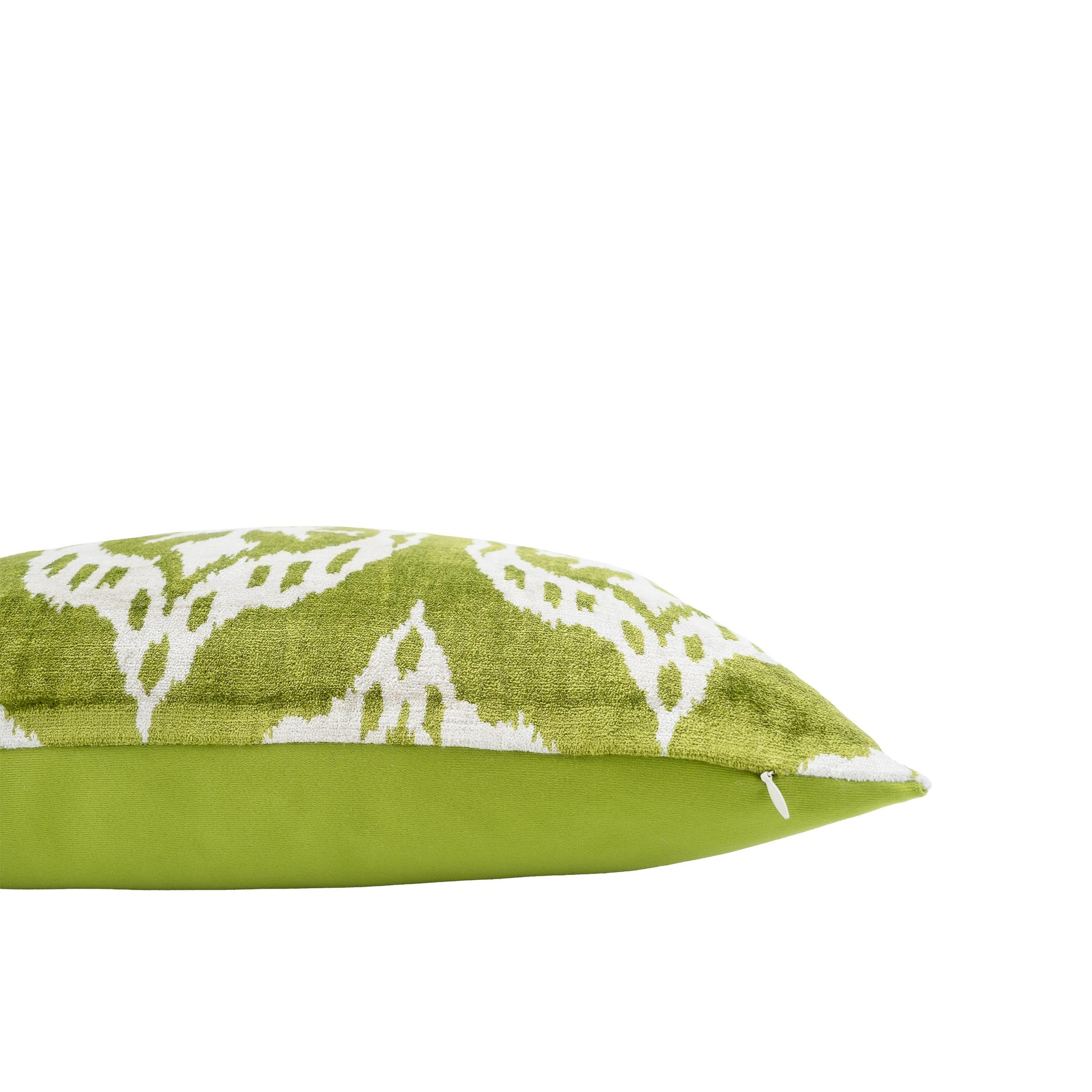 Handwoven silk velvet ikat pillow in vibrant green with intricate white symmetrical motifs.