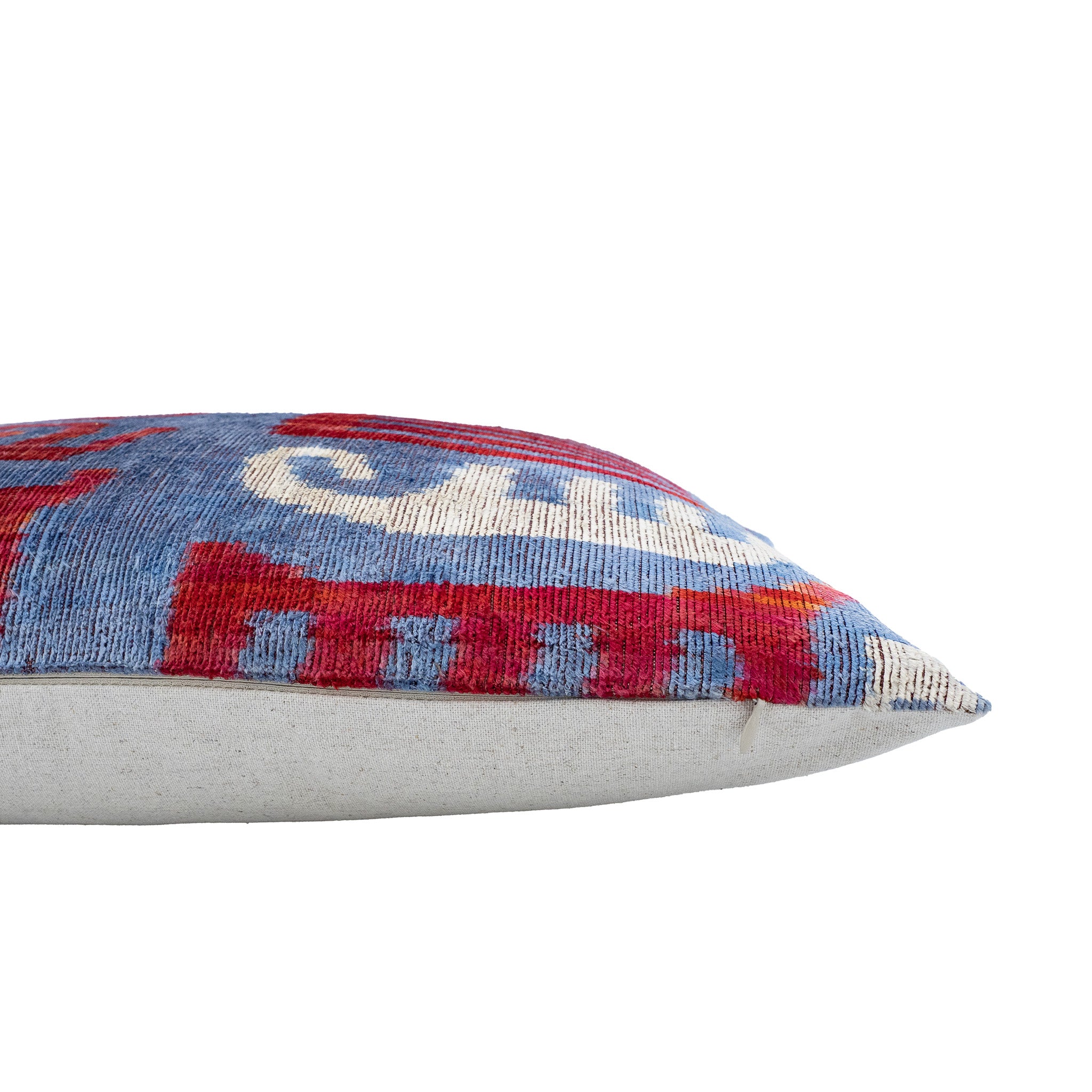 Handwoven rectangular ikat pillow cover in sky blue with vivid red and cream patterns.