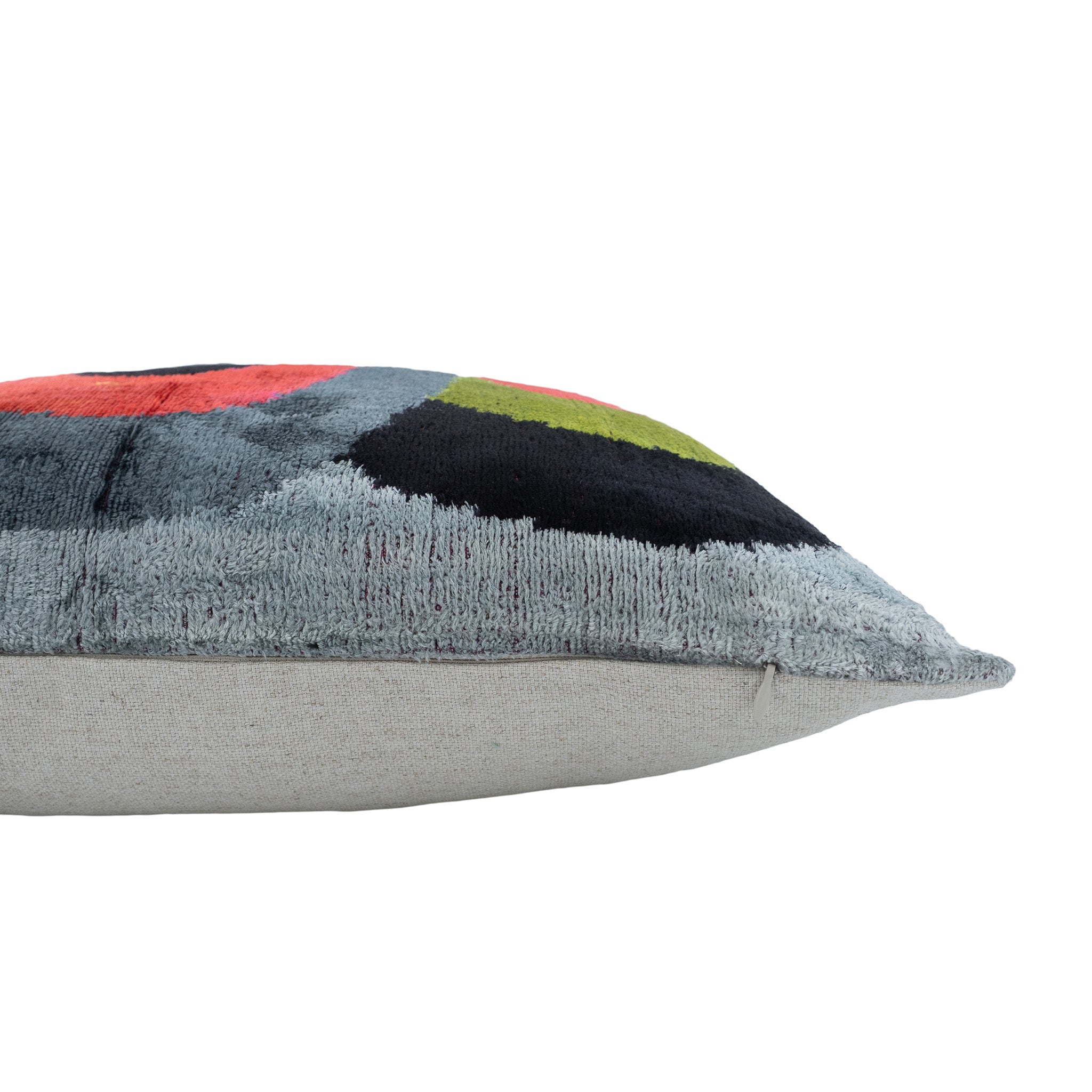 Handwoven silk velvet pillow with vibrant concentric ring patterns on gray base.