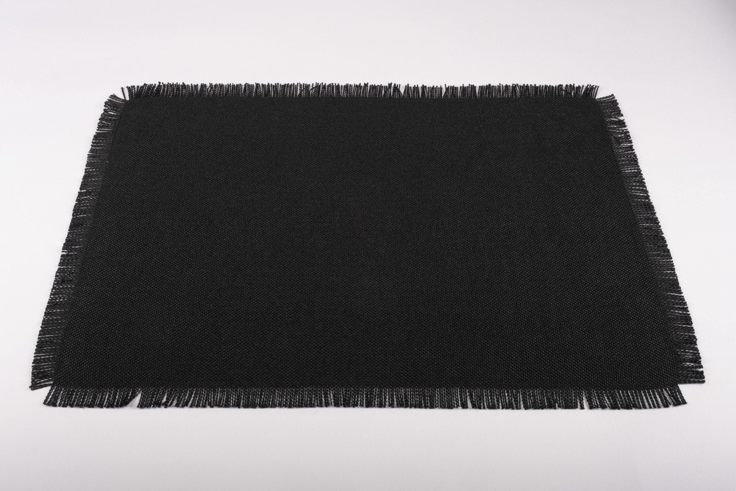 Handmade black placemats with fringes, designed for longevity, made from high-quality cotton and polyester for a chic dining experience.