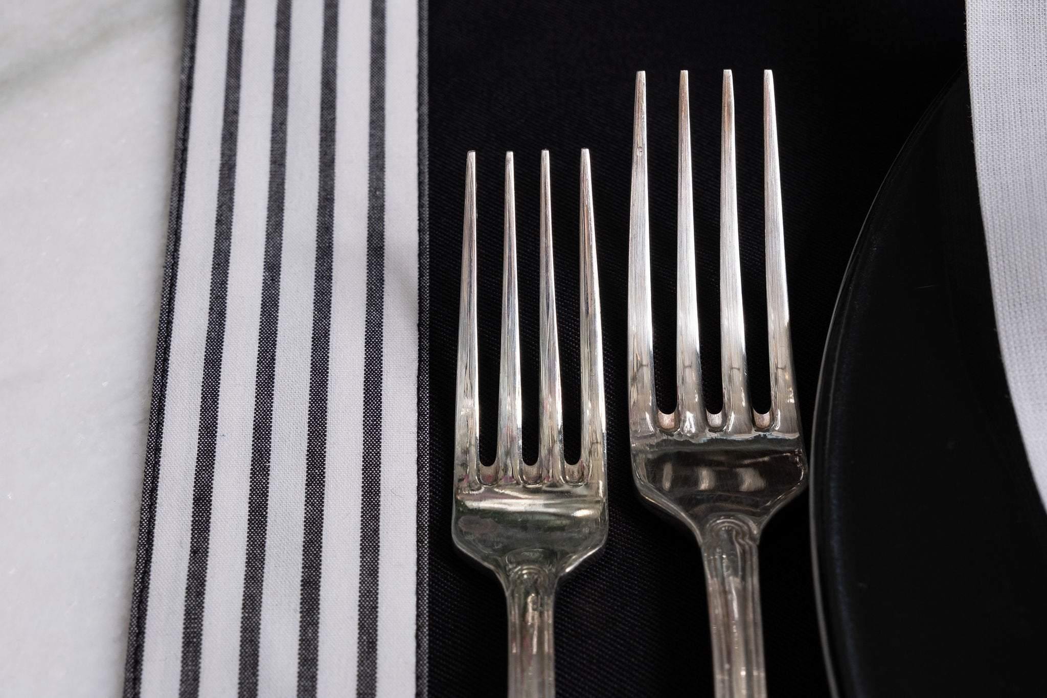 Durable black placemats with side stripes, set of 4, made for longevity and easy maintenance, perfect for any dining occasion.