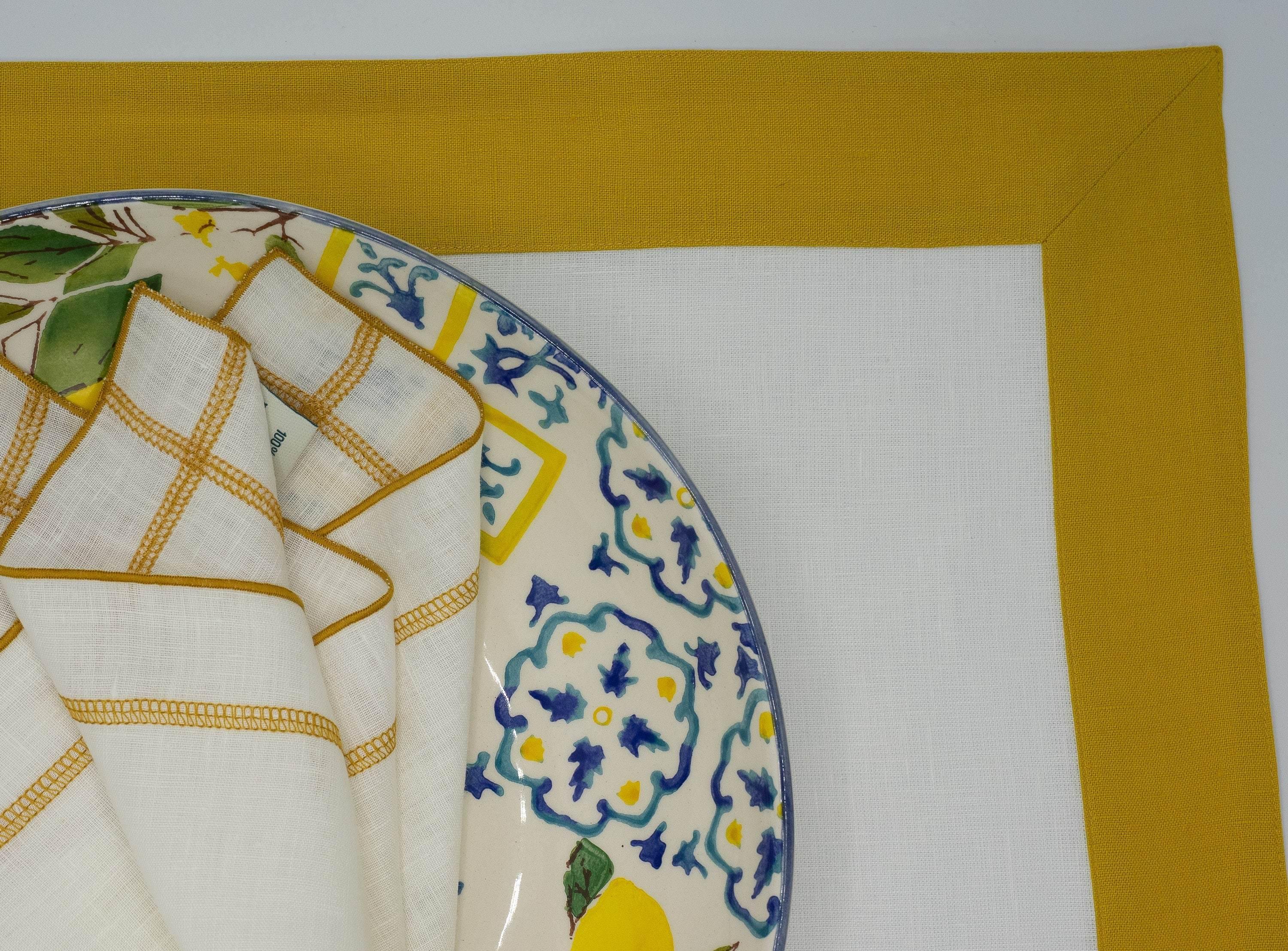 Linen placemats with mustard borders, offering luxurious texture and design for any table setting, from casual to formal.
