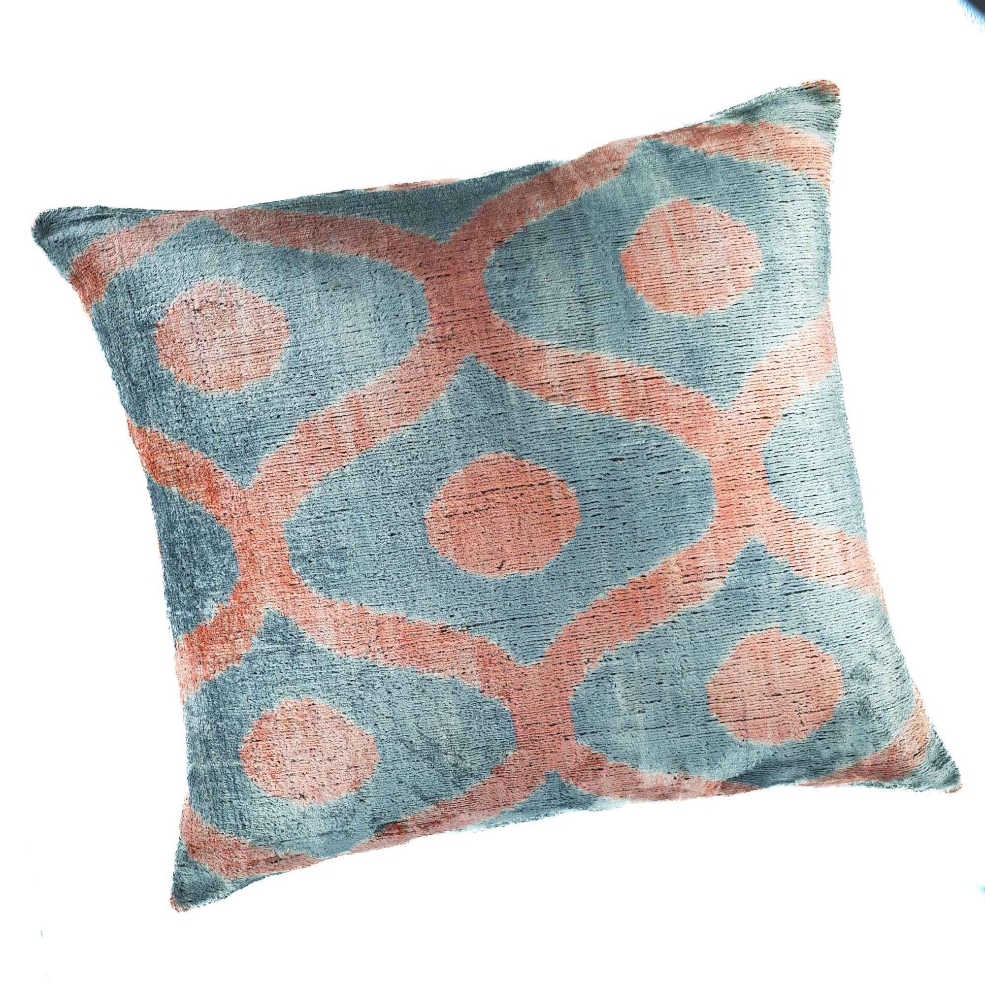 Elegant Blue Rain Ikat pillow by Chouchou Touch, showcasing intricate peach-toned circular motifs on a soft blue background.
