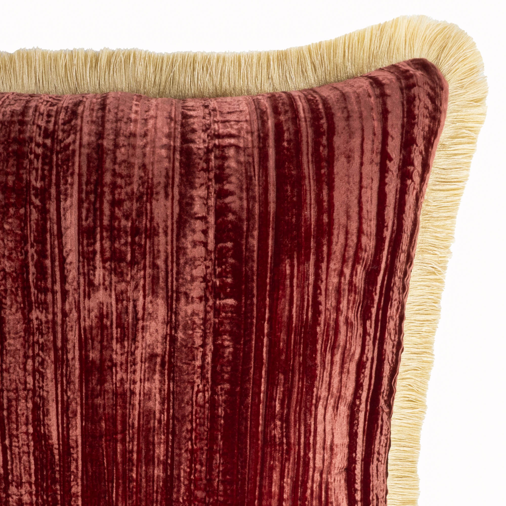 Rich red velvet throw pillow with decorative gold fringes, ideal for creating a refined living space.
