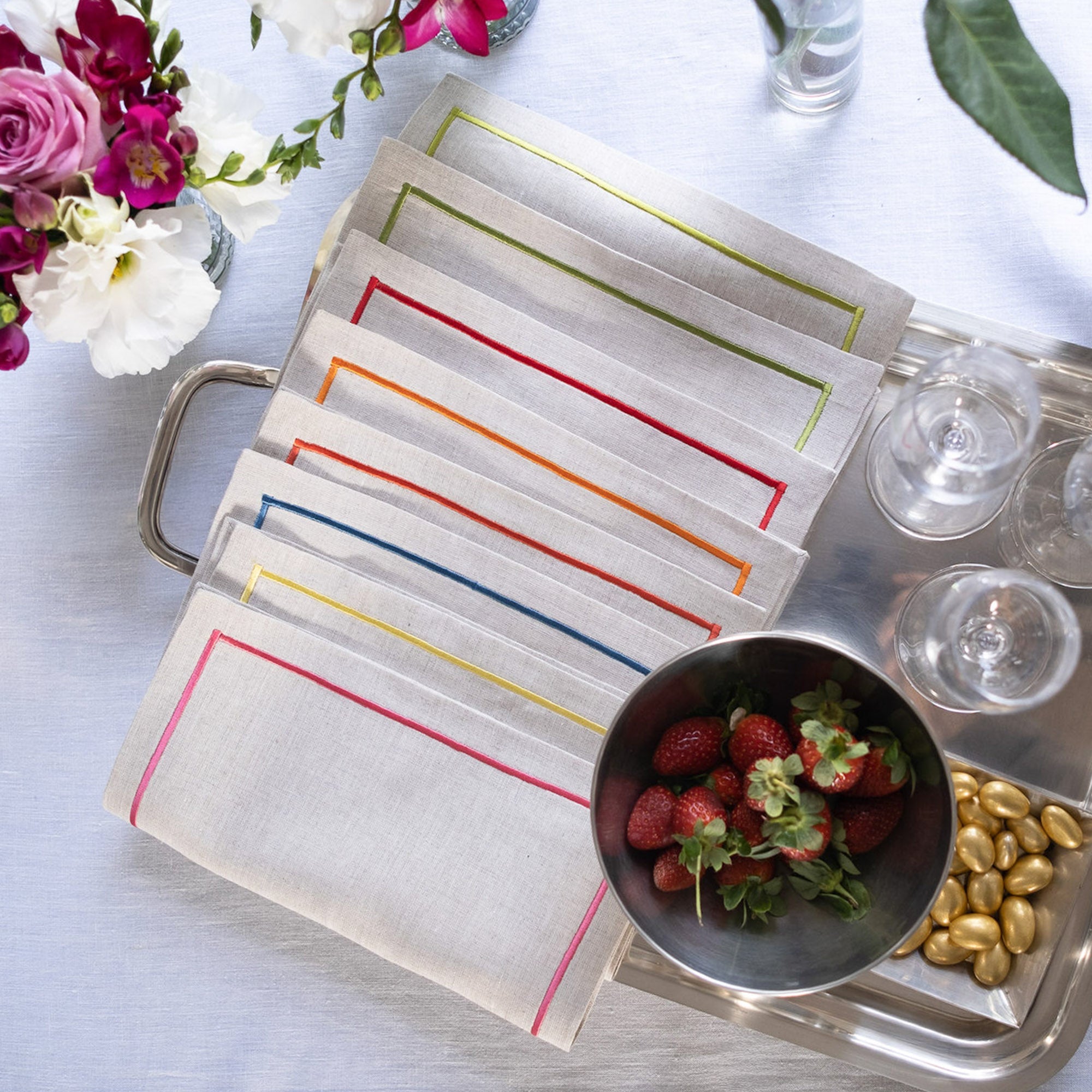 Elegant linen cocktail napkins with colorful embroidered borders styled for entertaining