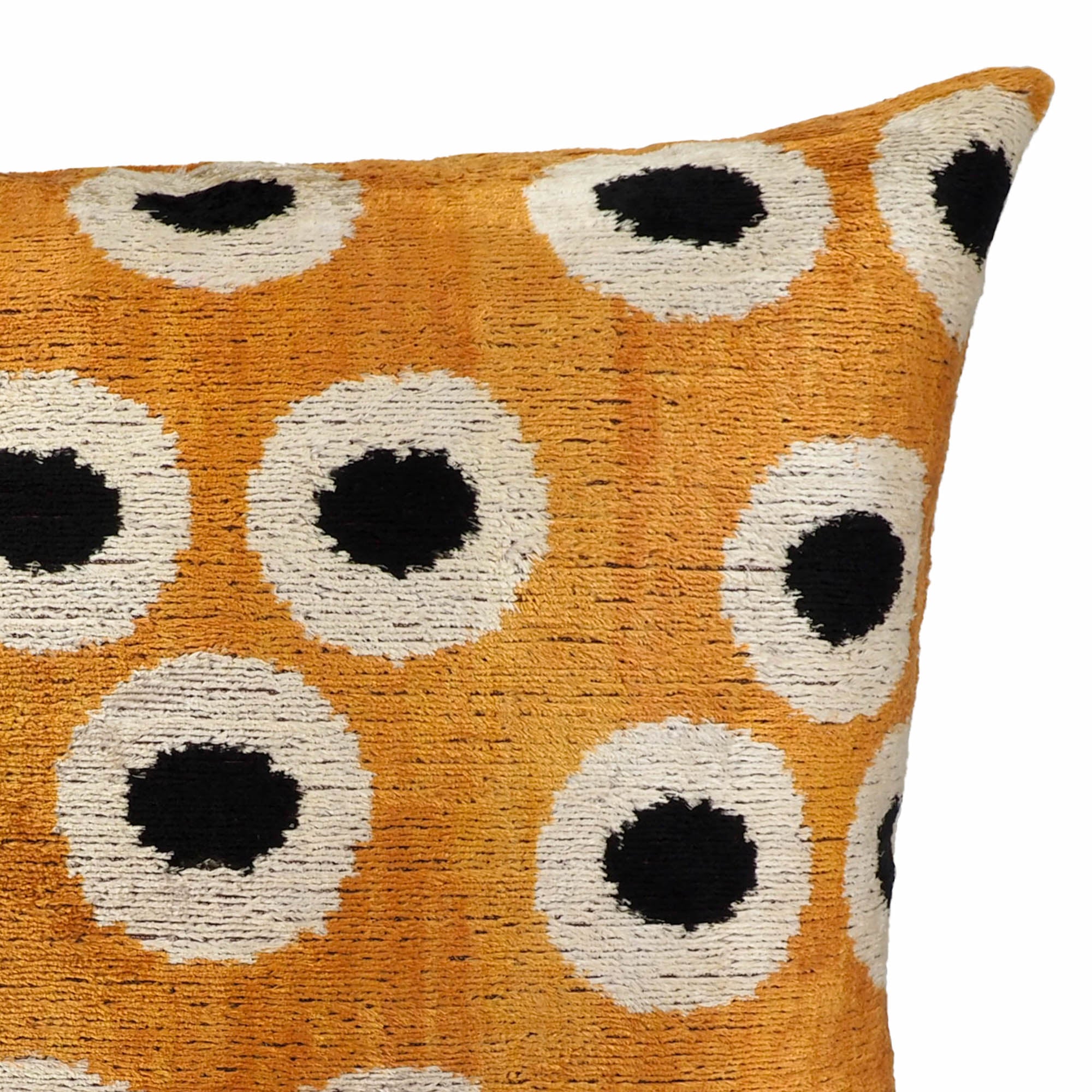 Close-up of handmade orange silk velvet ikat fabric featuring bold black and ivory orb motifs, showcasing artisan craftsmanship and rich velvet texture.
