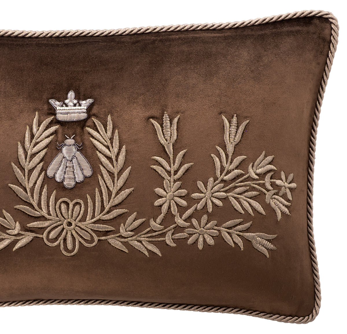 Detail of Regina brown silk velvet pillow cover showing floral embroidery, the crowned bee motif and twisted cord trim along the right edge.
