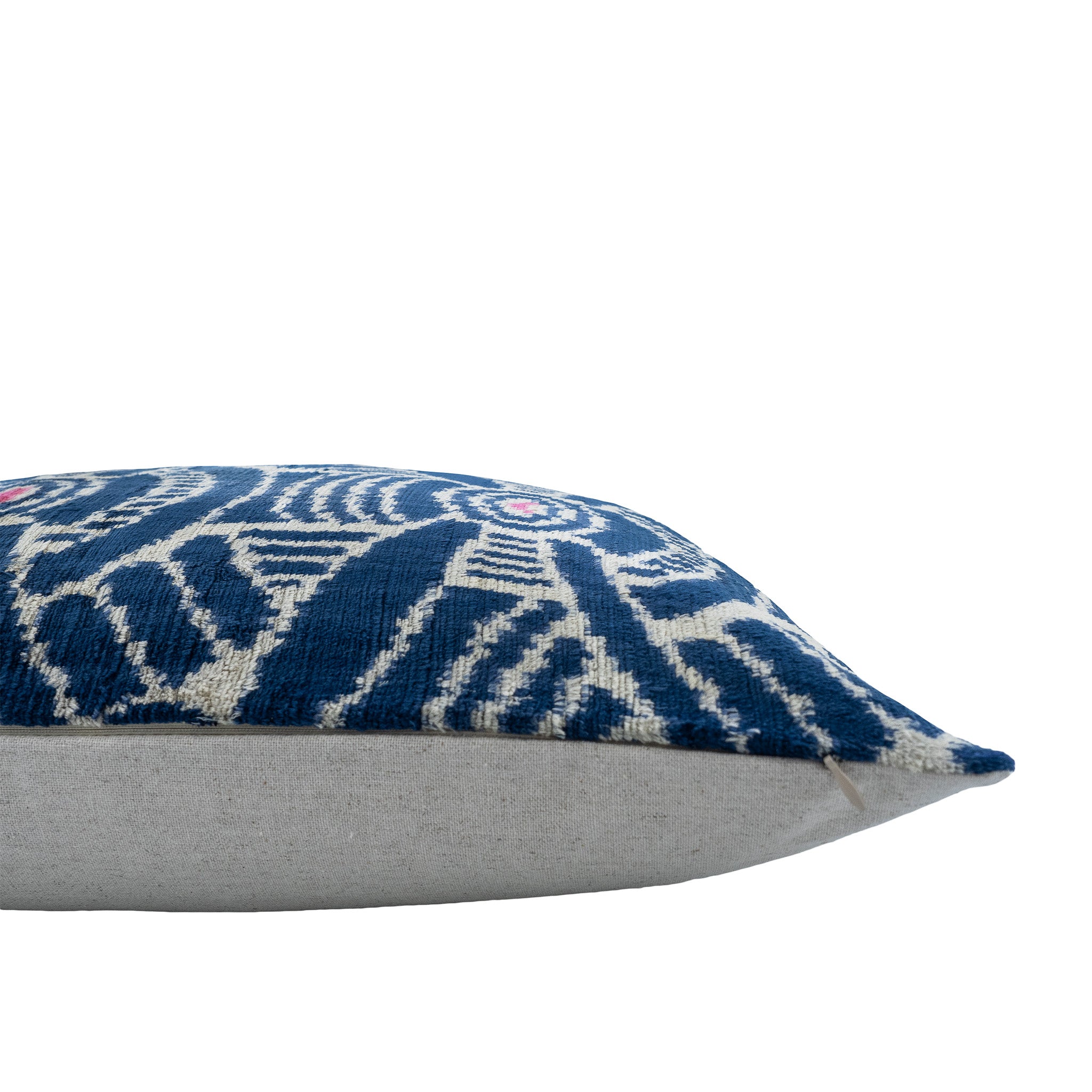 Handwoven Kelly Ikat pillow cover crafted from 100% silk velvet, featuring intricate blue and white designs with pink details.
